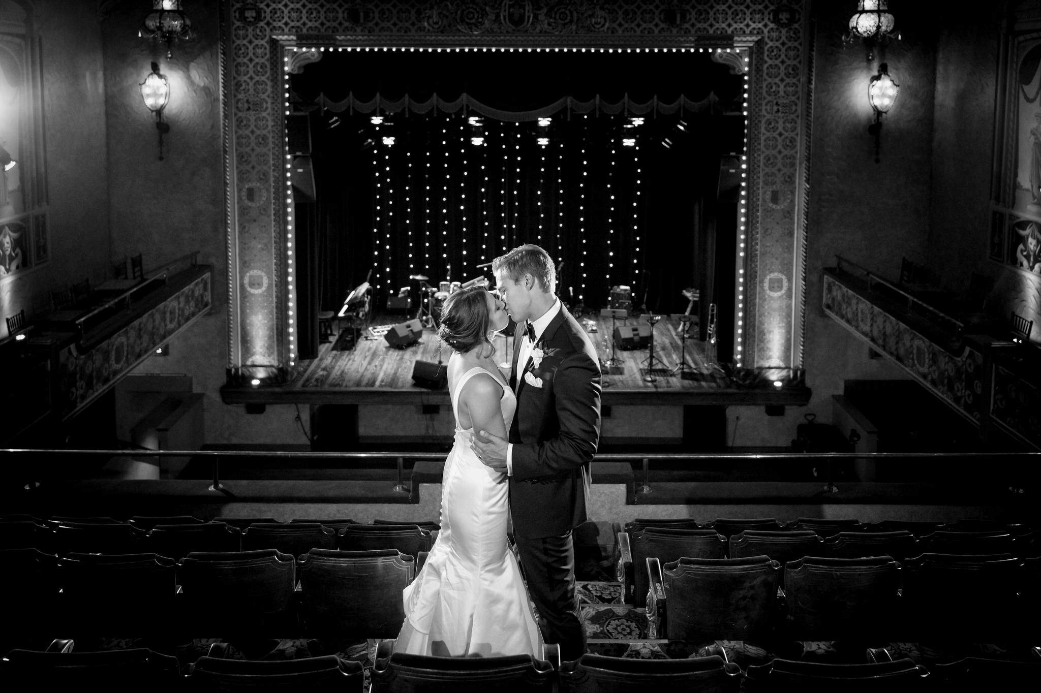 A bride and groom kiss in the balcony overlooking their Gem Theatre Detroit wedding reception.  
