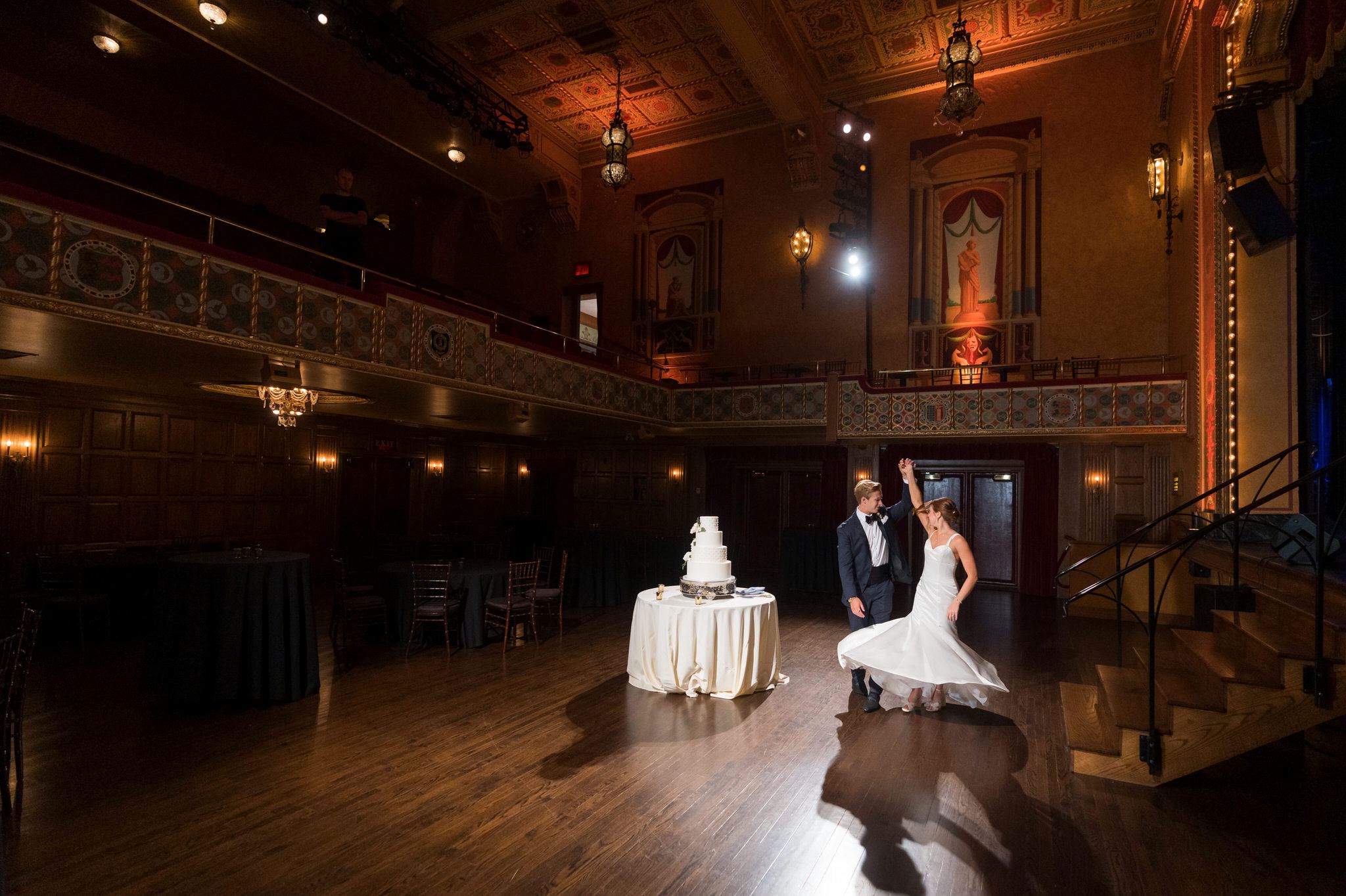A groom twirls his bride on the dance floor of their Gem Theatre Detroit wedding reception.  
