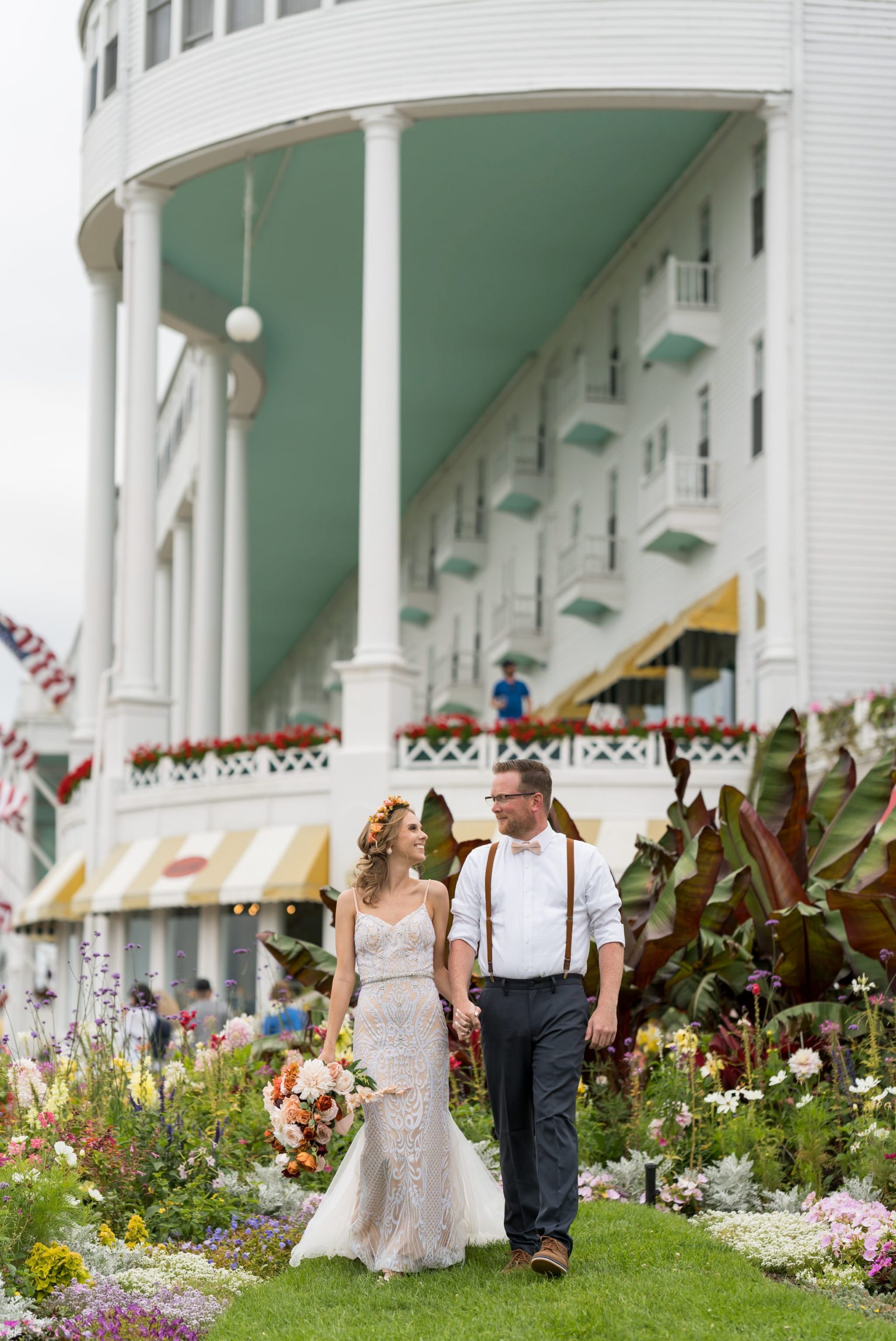 A bride and groom walk away from the Grand Hotel on Mackinac Island.  