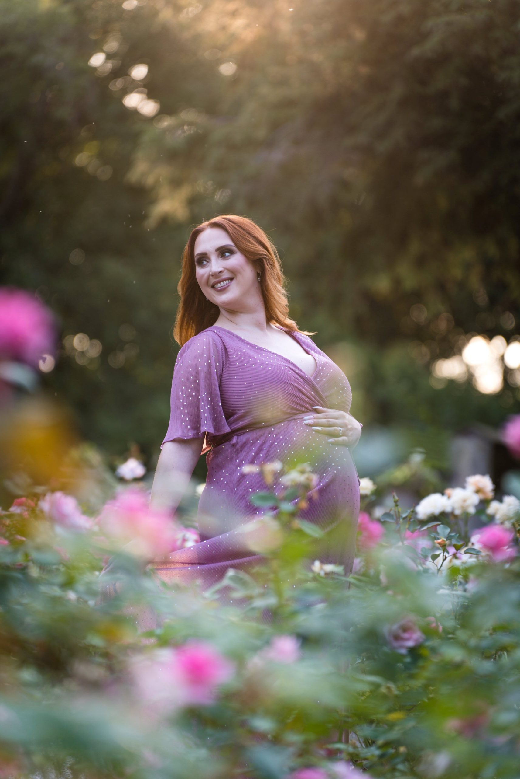 A pregnant mom holds her bump during a maternity session at Edsel Ford House.