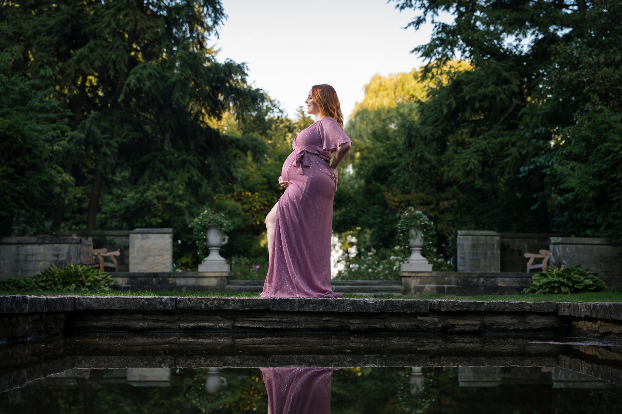 An expecting mom holds her bump during her maternity session at Edsel Ford