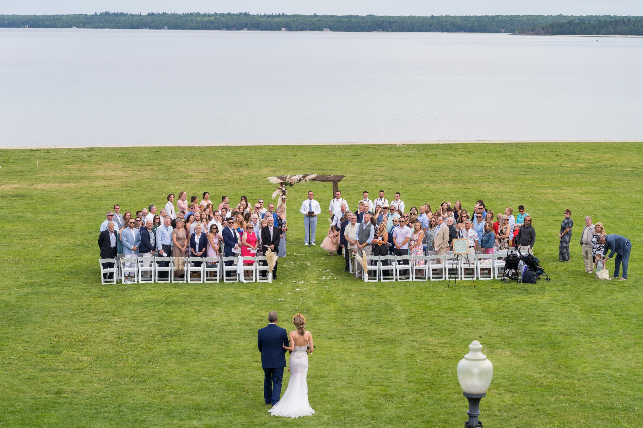 An aerial view of a bride walking toward her Mission Point Resort wedding ceremony on Mackinac Island.