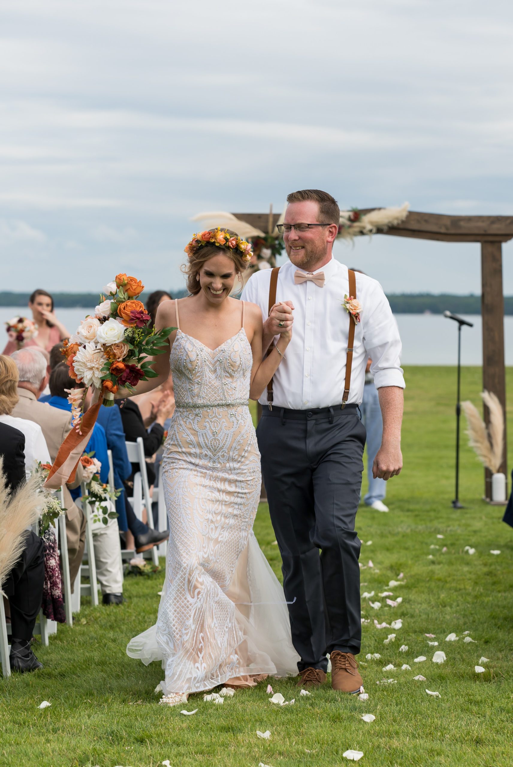 A bride and groom, holding hands, laugh as they are announced as husband and wife during their Mission Point Resort wedding.
