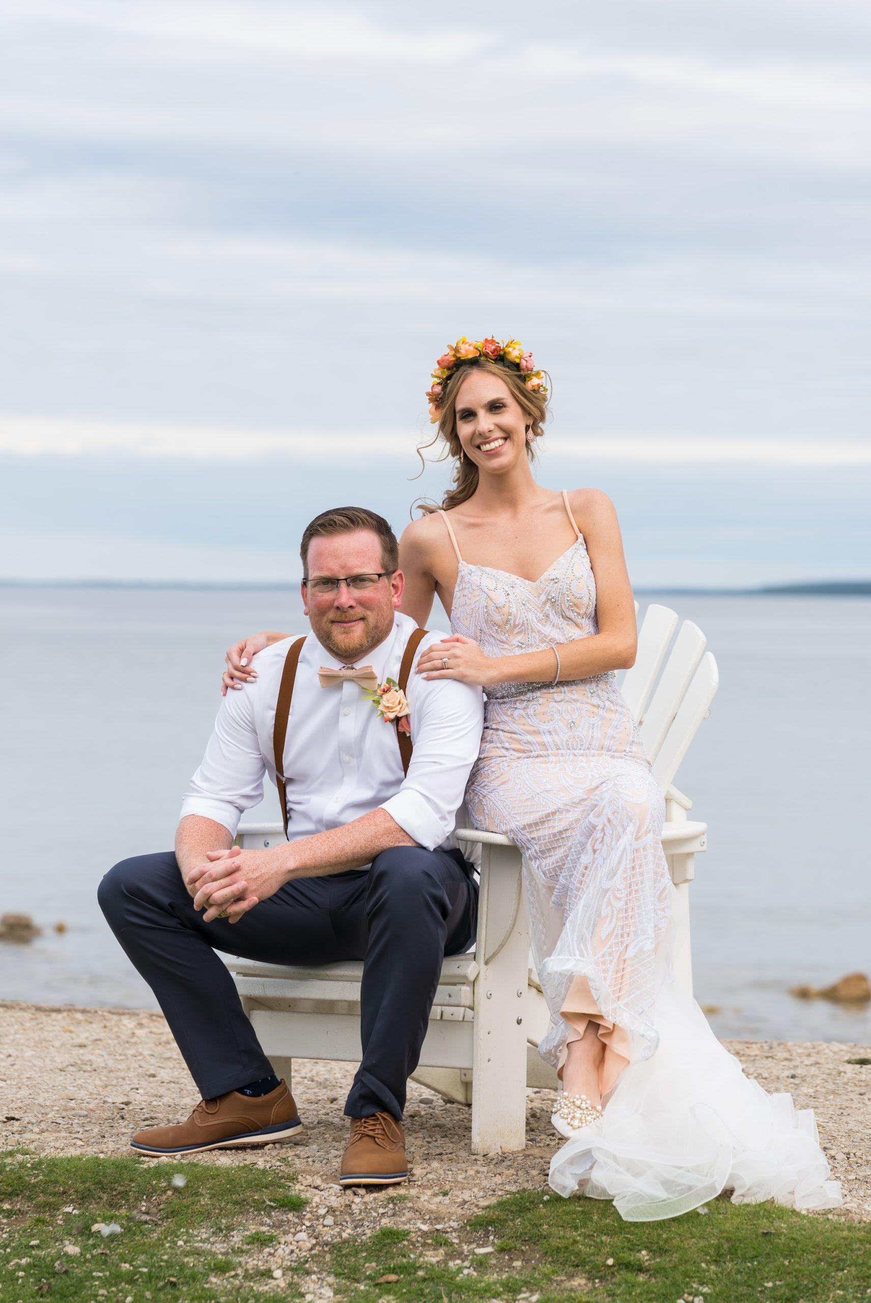 A bride and groom sit on adirondack chair on Mackinac Island.
