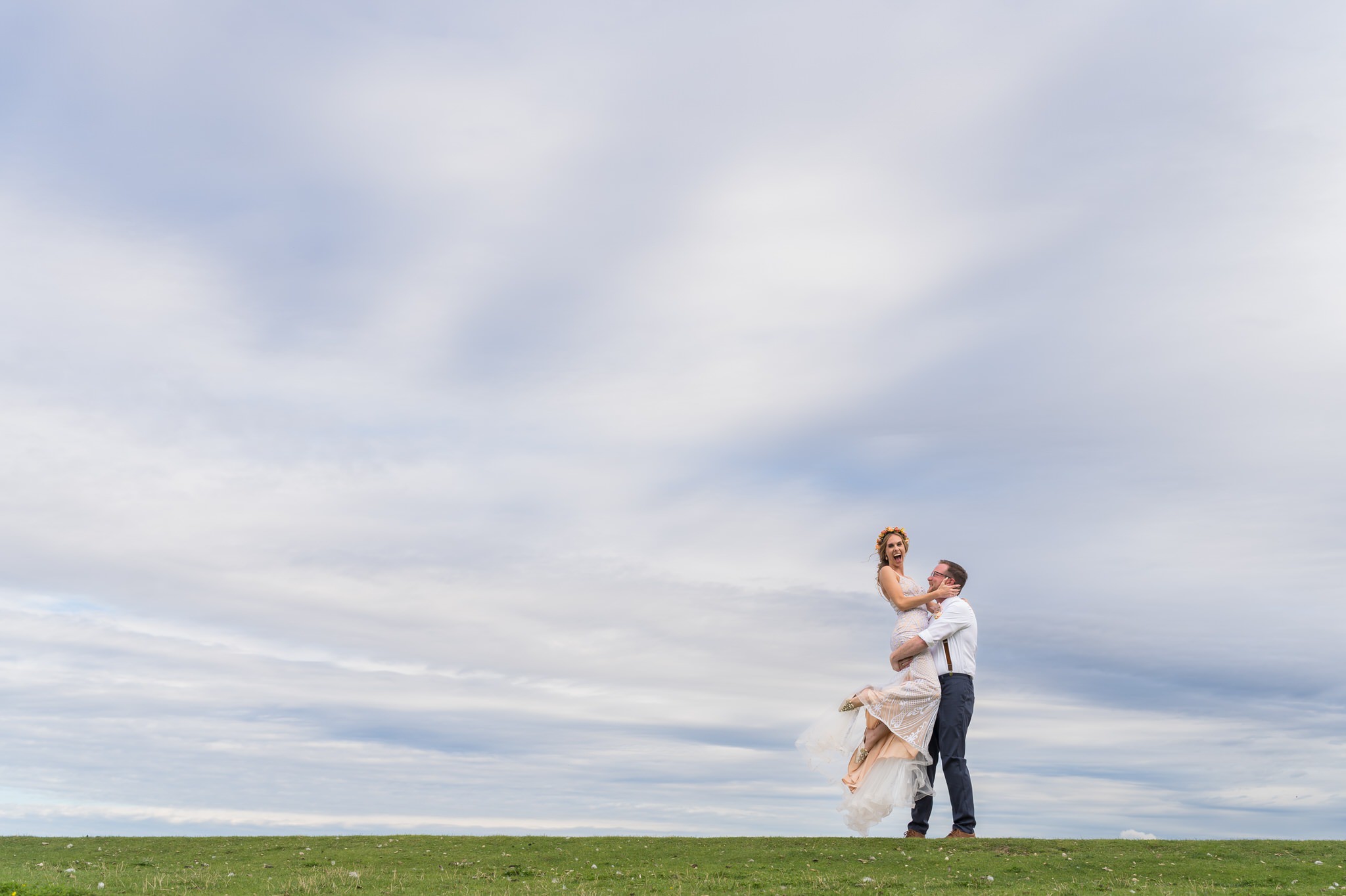 A groom lifts and twirls his bride on the grounds of a Mission Pointe Resort wedding.  