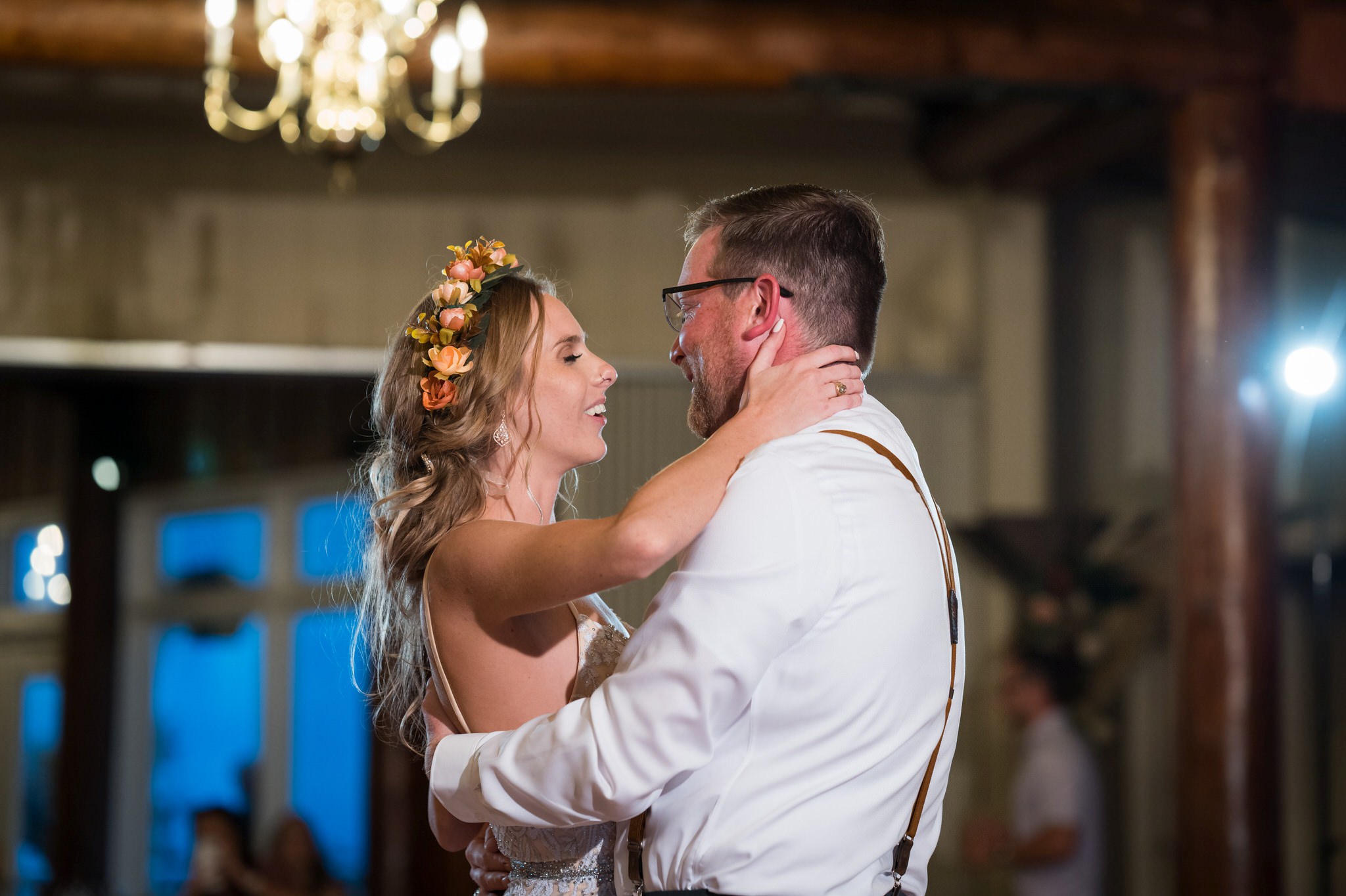 A bride holds her groom's head while slow dancing at a Mission Pointe Resort wedding. 