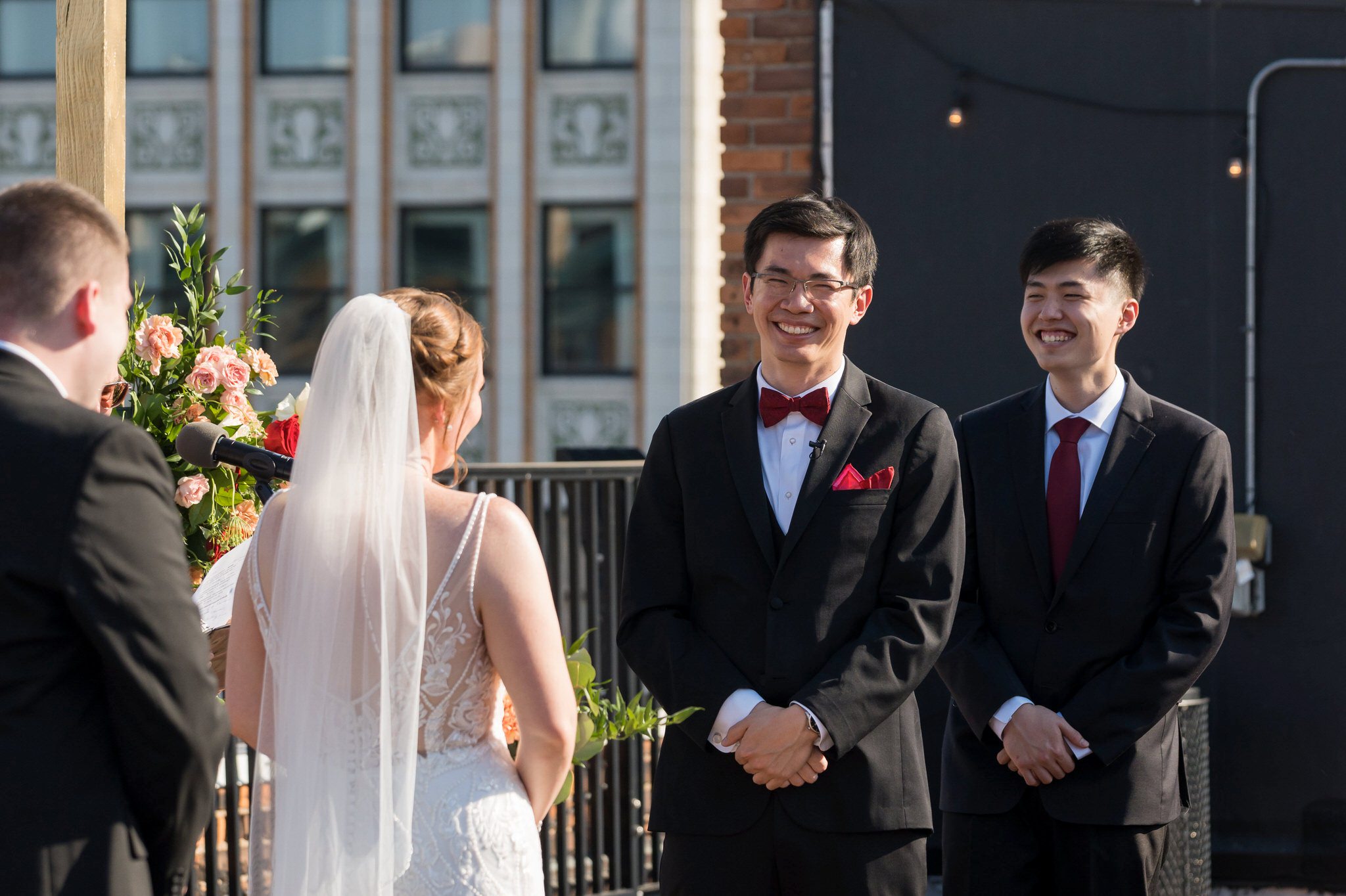 A groom smiles at his rooftop wedding at Detroit Opera House. 