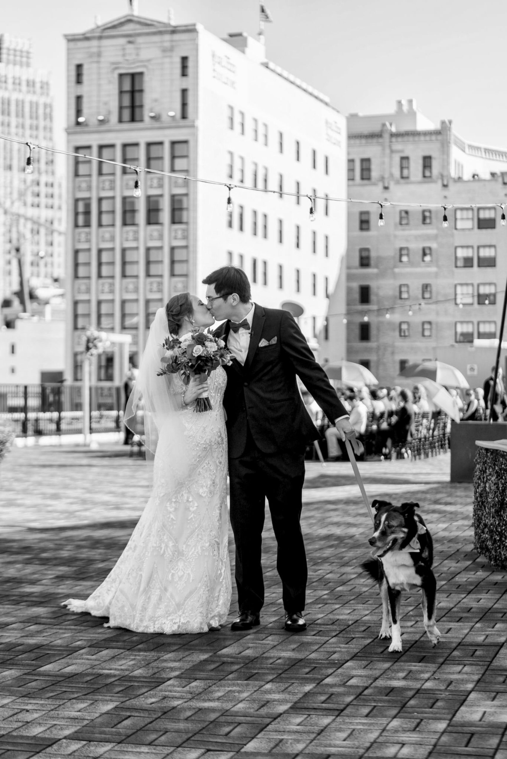 A bride and groom kiss after walking down the aisle at their rooftop wedding at Detroit Opera House. 