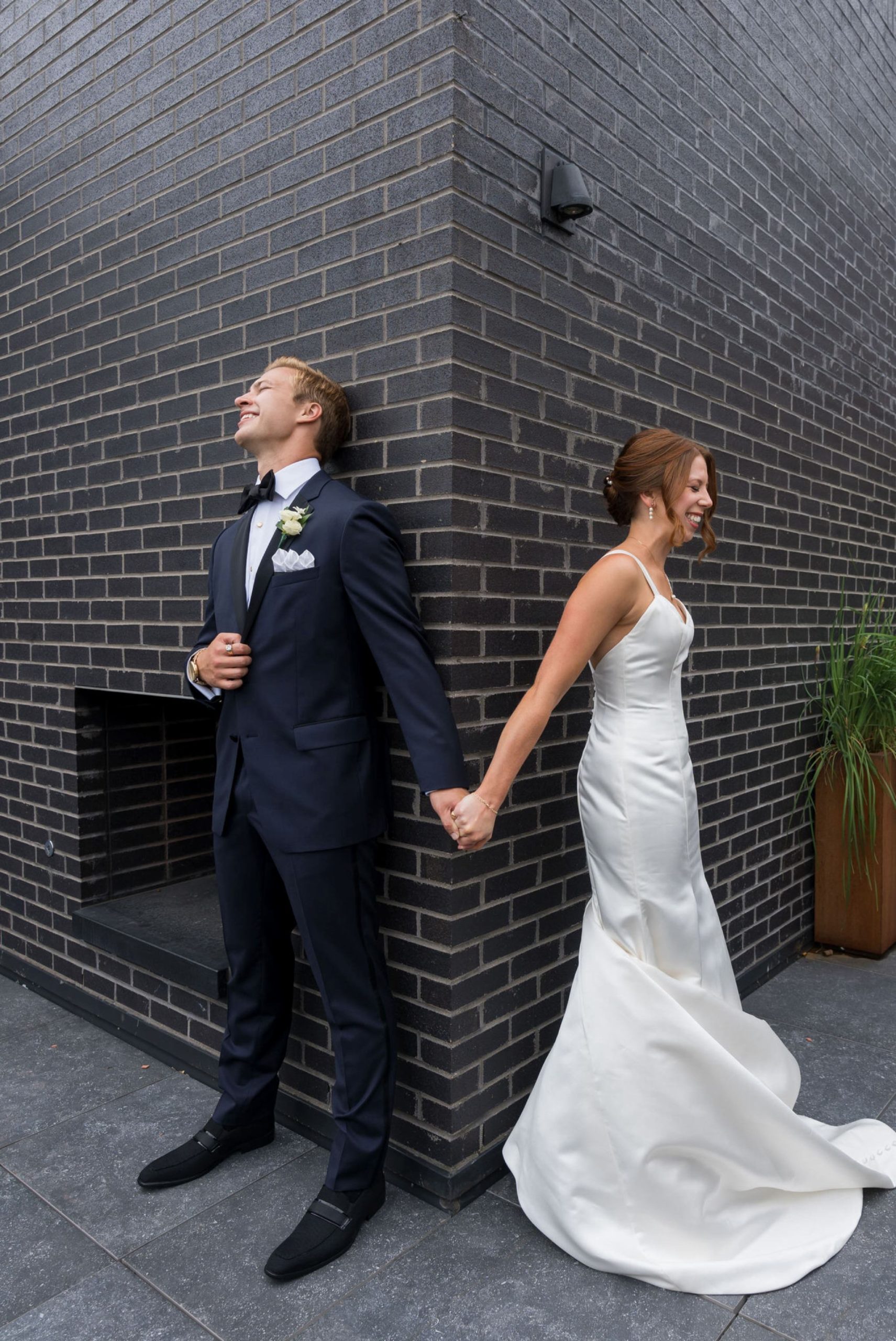 A bride and groom react to holding hands hand without seeing each other on their wedding day in Detroit.  