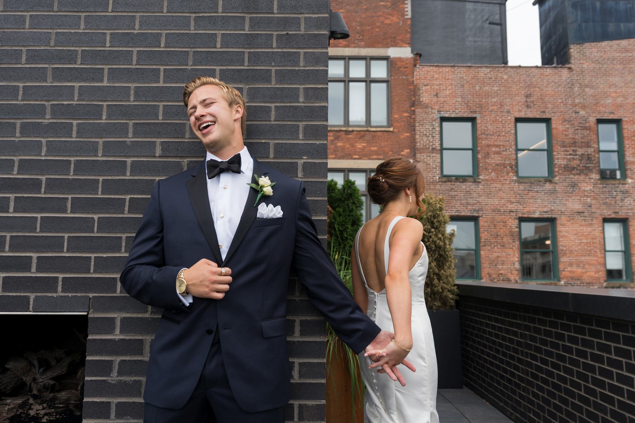 A groom reacts to feeling his wife's hand without seeing her on their wedding day in Detroit.  