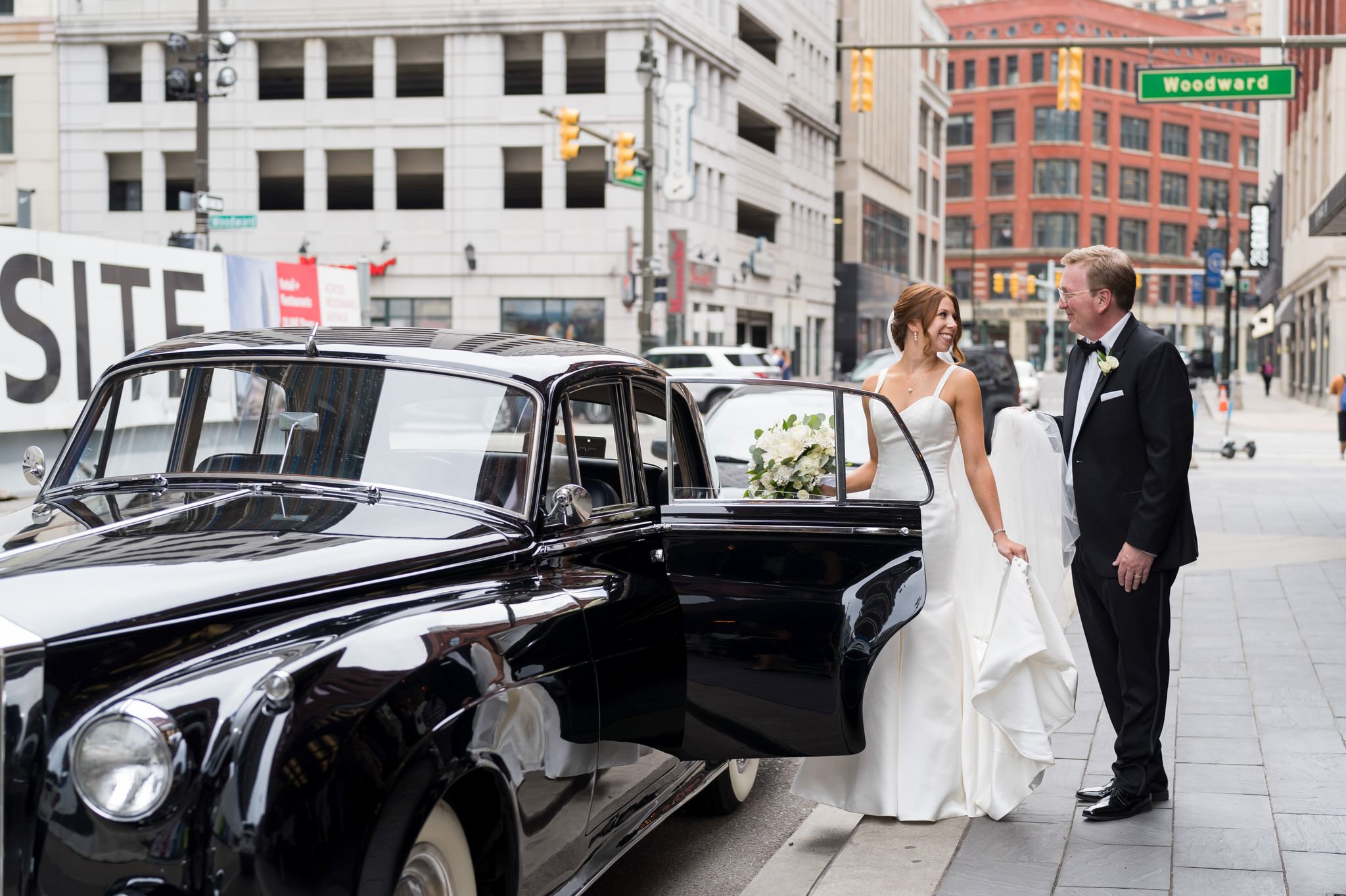 A bride steps into a black Rolls Royce outside of the Shinola Hotel in Detroit.  