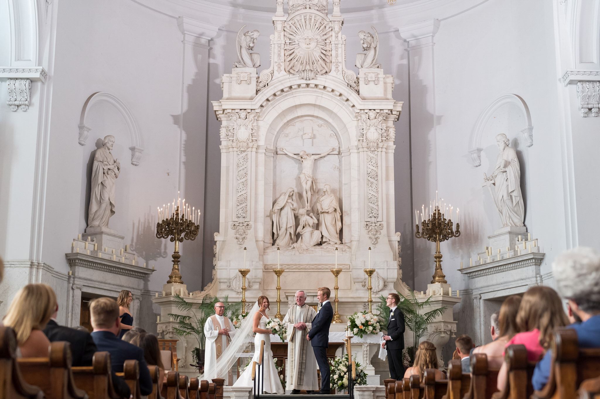 A bride and groom stand up at the altar of Saints Peter and Paul Jesuit Church in Detroit.  