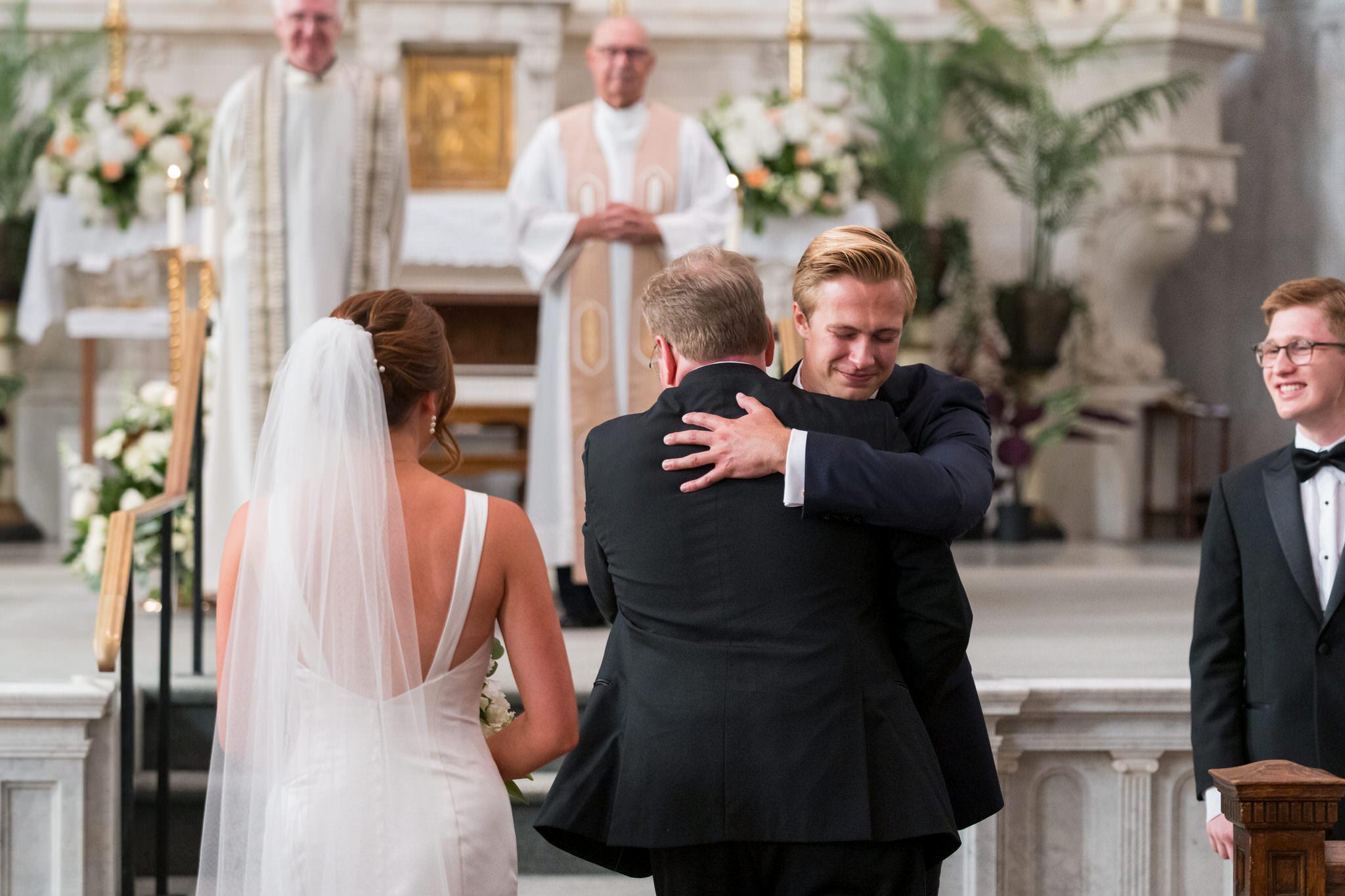 A groom hugs his father-in-law during a wedding ceremony at Sts Peter and Paul Jesuit Church in Detroit.  
