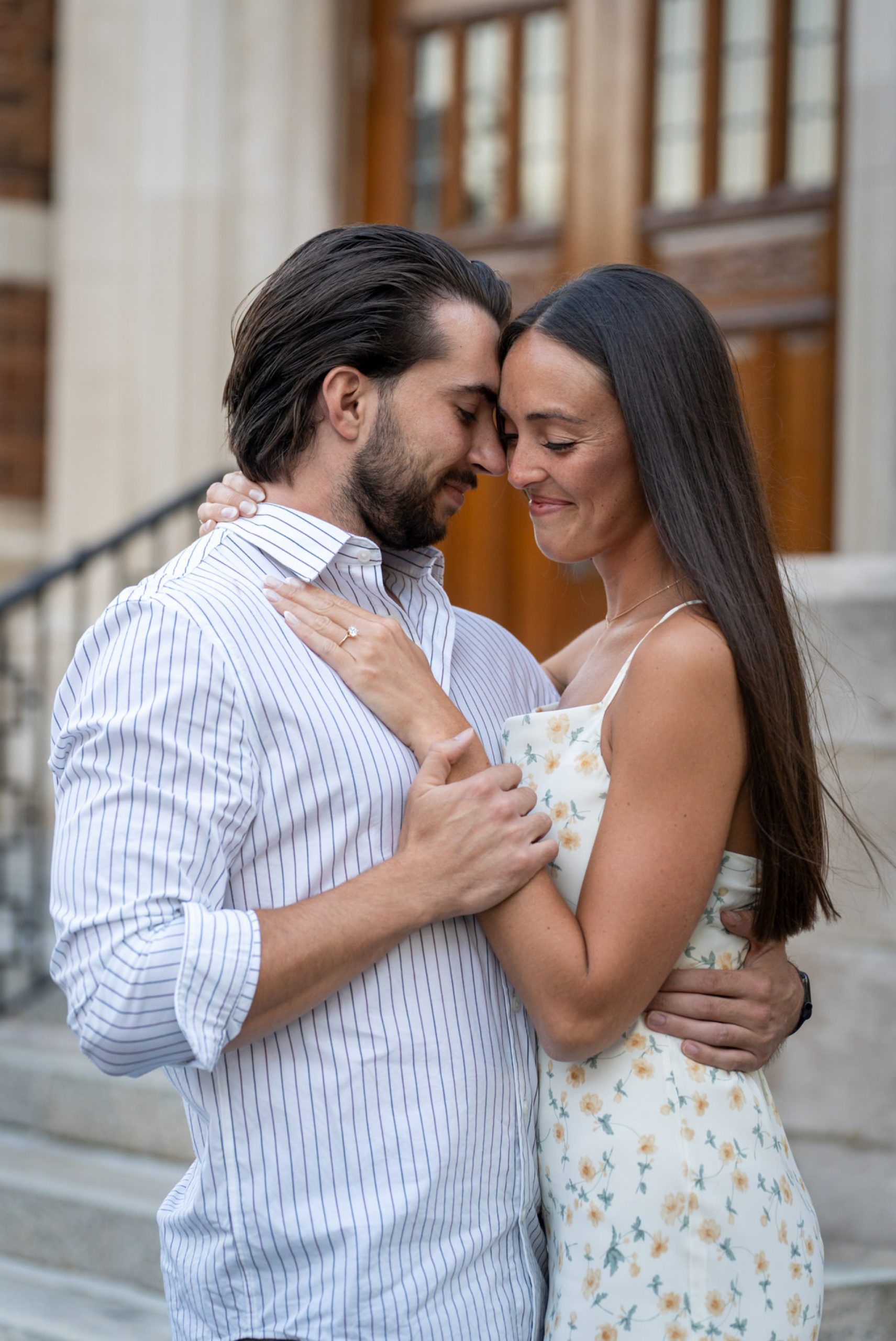 a couple embrace, touching foreheads during a downtown Birmingham proposal 