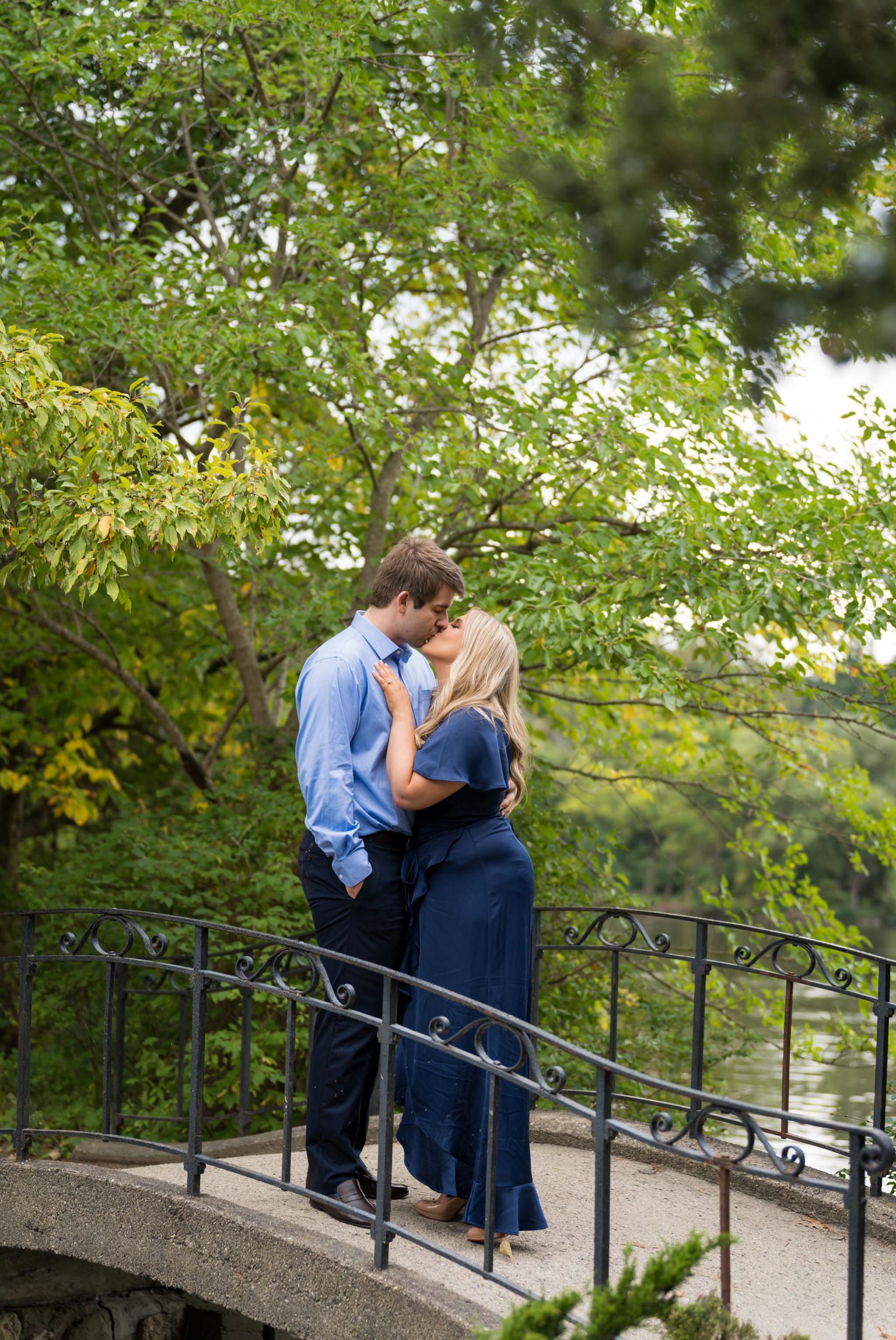 A couple, dressed in blue, kiss on a small bride on Cranbrook's campus in Bloomfield Hills. 