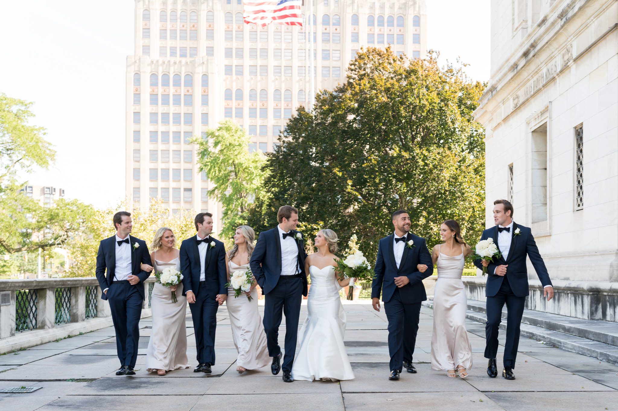 A bridal party walks and laughs outside of the Detroit Public Library.  