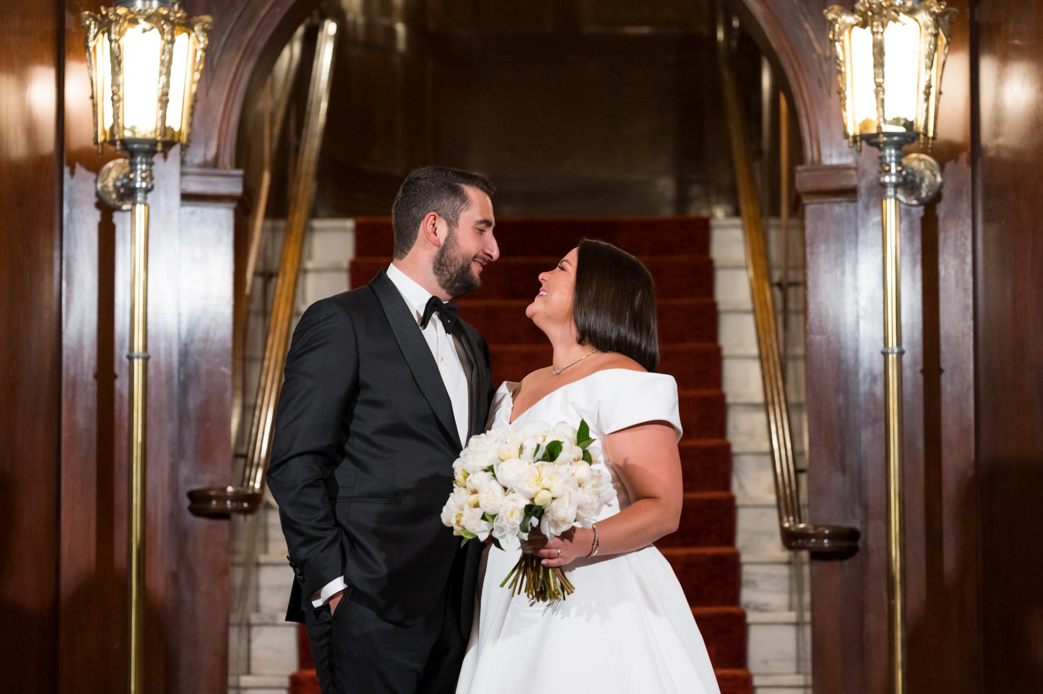 A bride and groom hold and look at each other at their Detroit Orchestra Hall wedding.