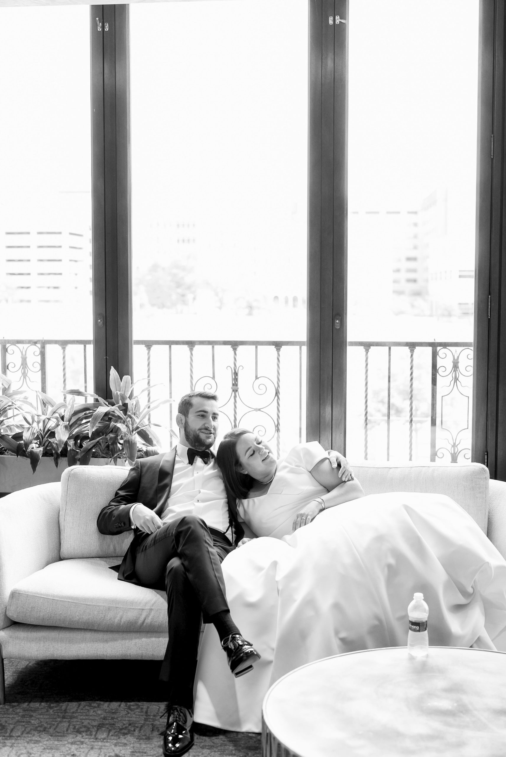A bride and groom relax on a couch in Paradise Lounge at their Detroit Orchestra Hall wedding.  