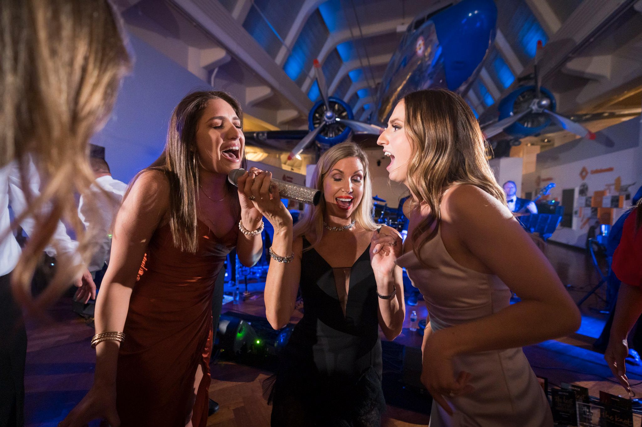 Girls sing into a microphone at a Henry Ford Museum wedding reception. 