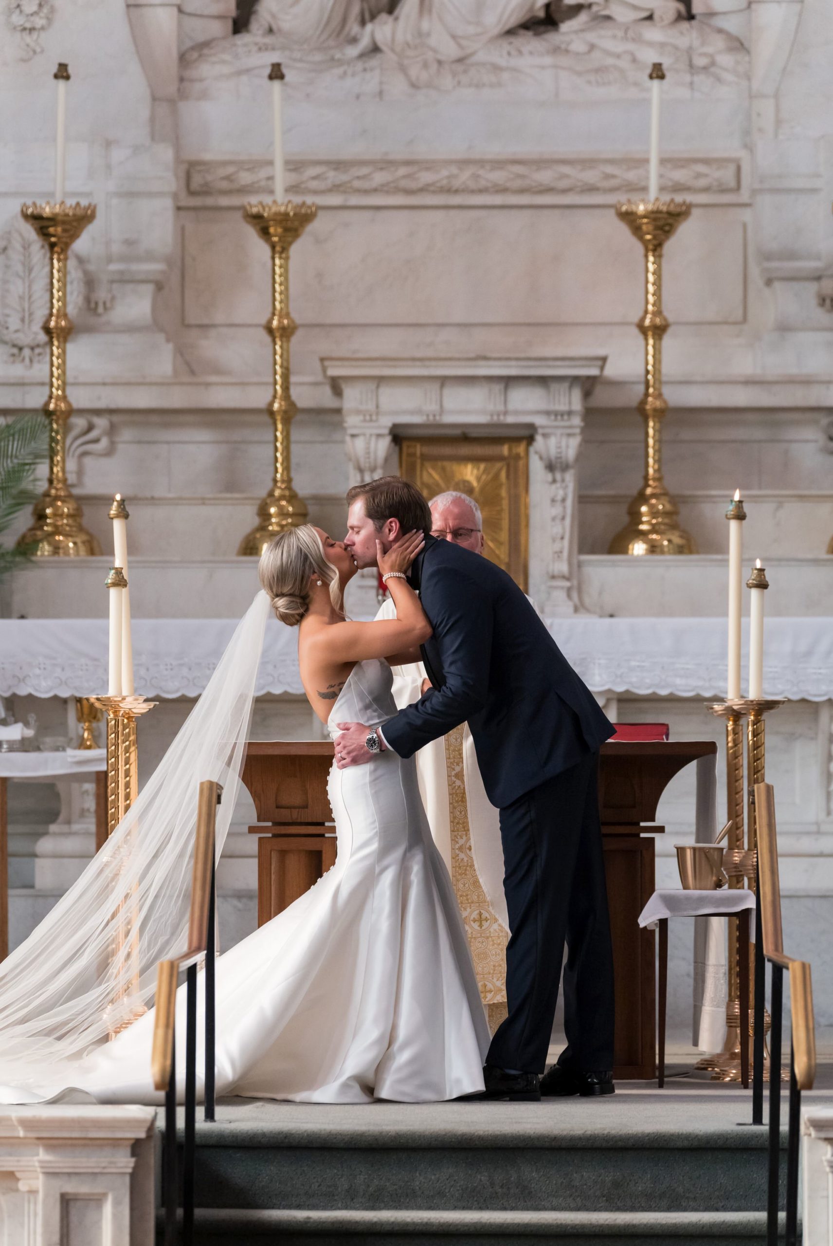 A bride and groom share a first kiss at the altar at Saints Peter and Paul Jesuit Church in Detroit.  