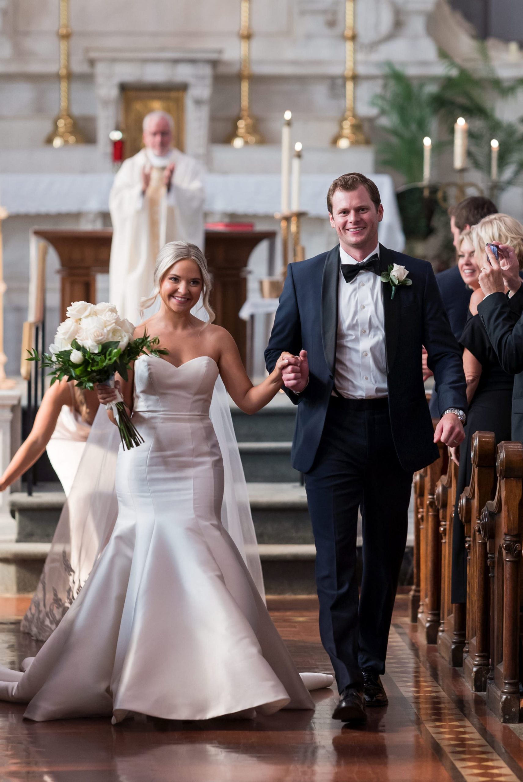 A bride and groom walk down the aisle at their wedding at Saints Peter and Paul Jesuit Church in Detroit.  