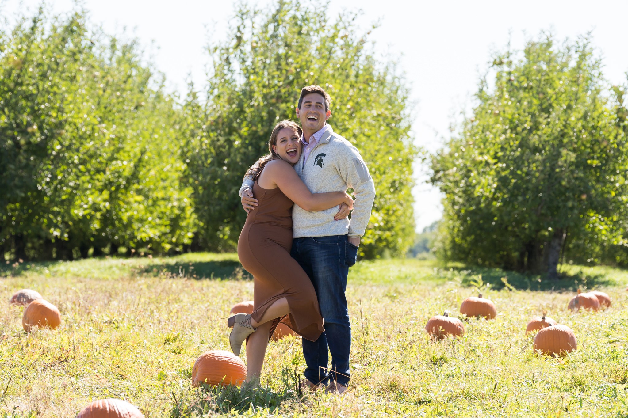 A couple celebrates after a pumpkin patch proposal at Blake's Apple Orchard.