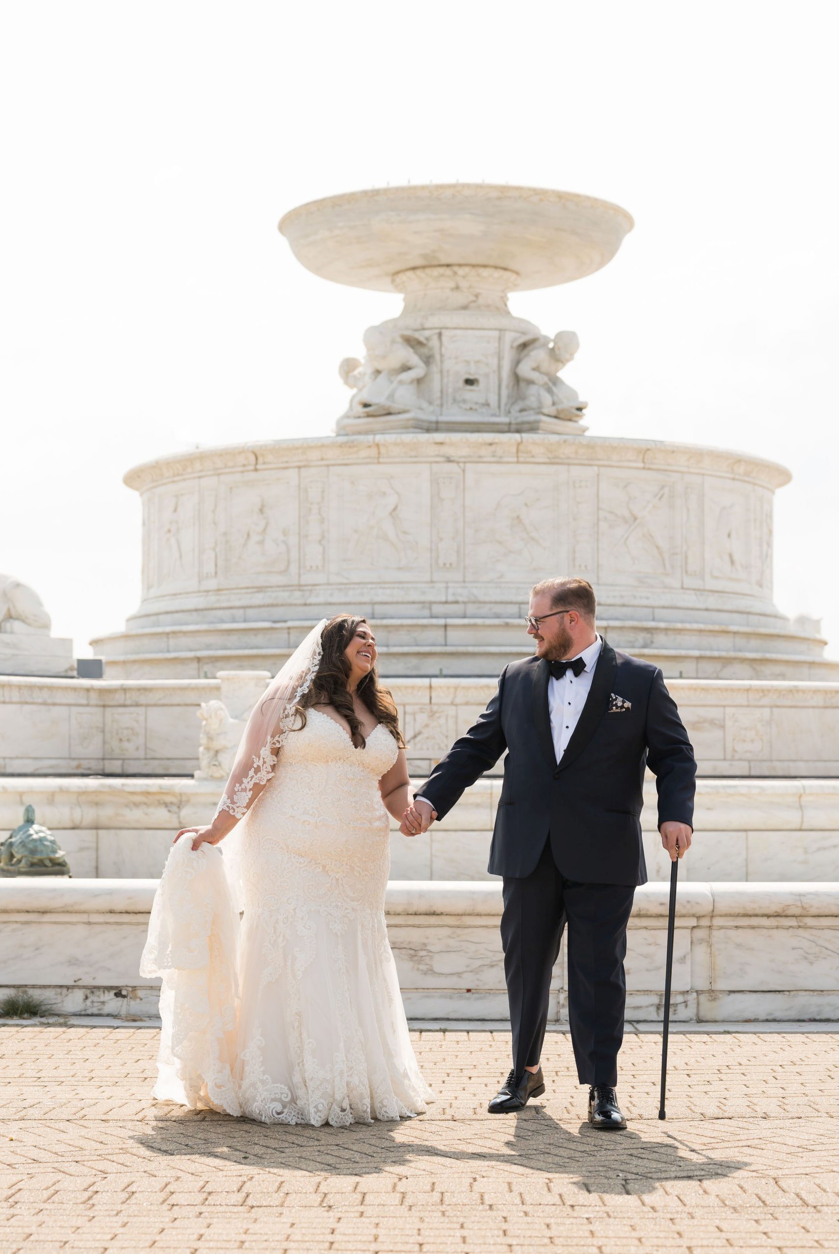 A married couple walks away from the Belle Isle Fountain on their wedding day. 