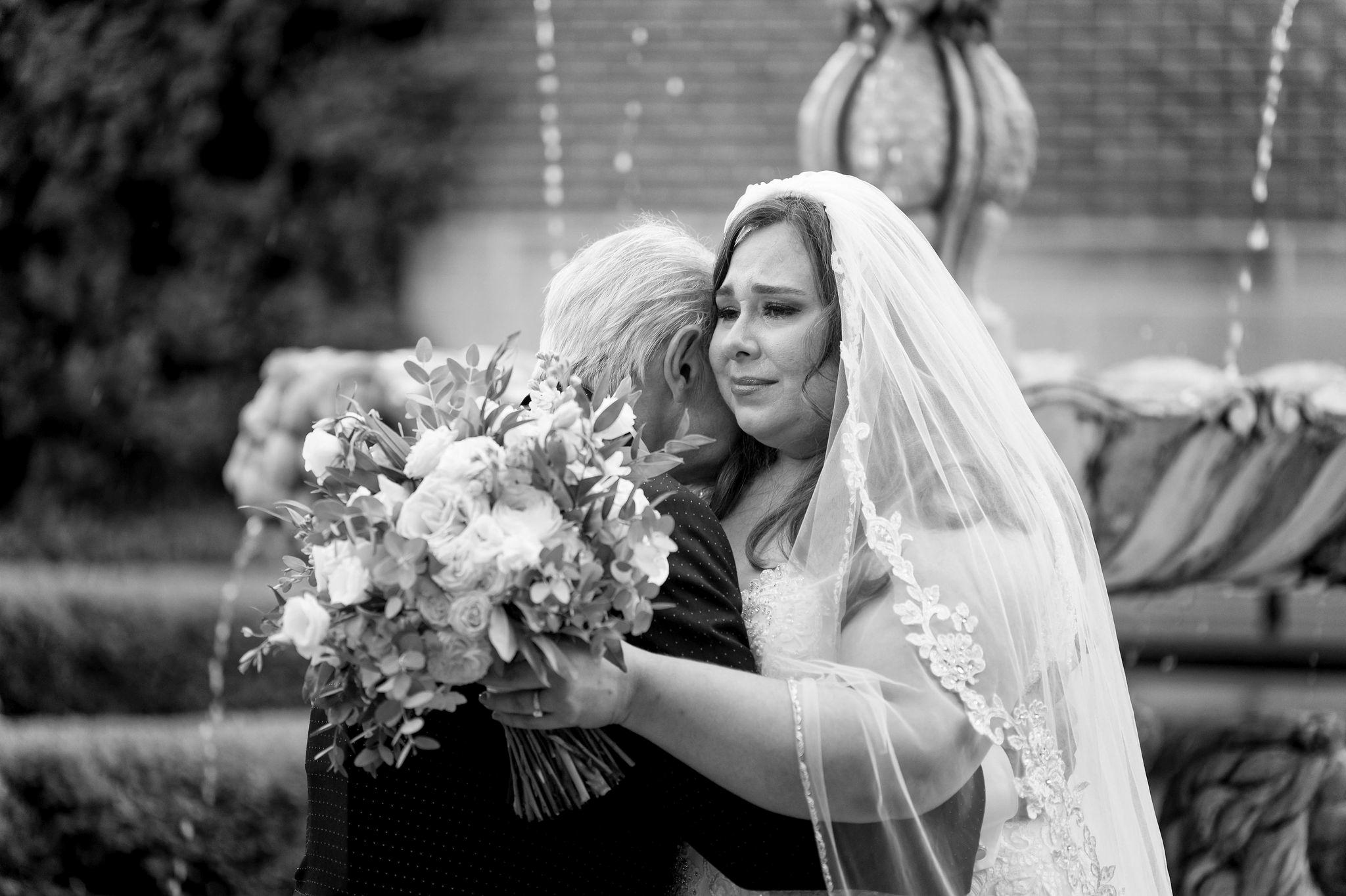 A dad embraces his daughter, the bride, on her wedding day. 