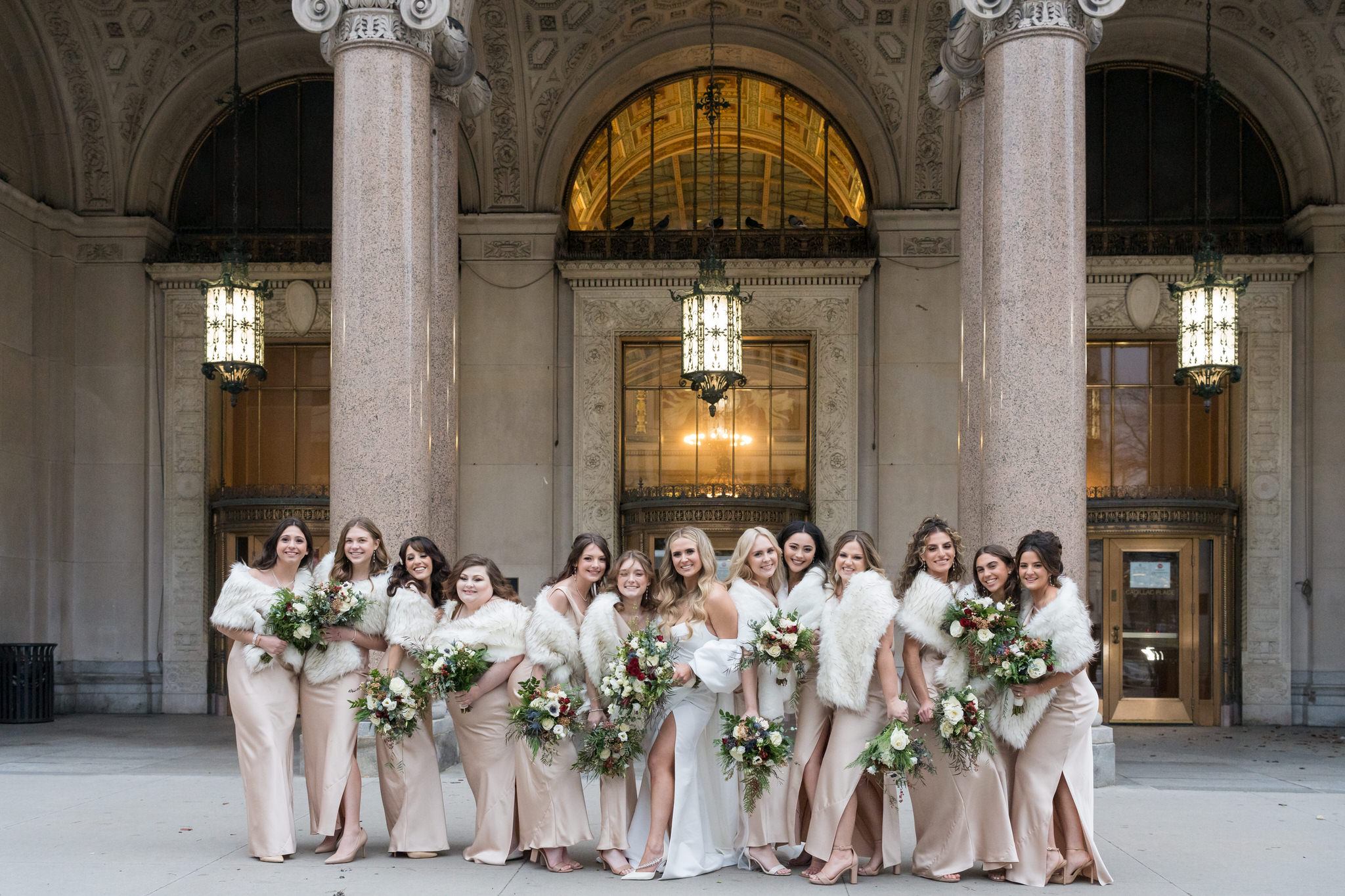 Bridesmaids pose in a line at Cadillac Place in Detroit, MI.