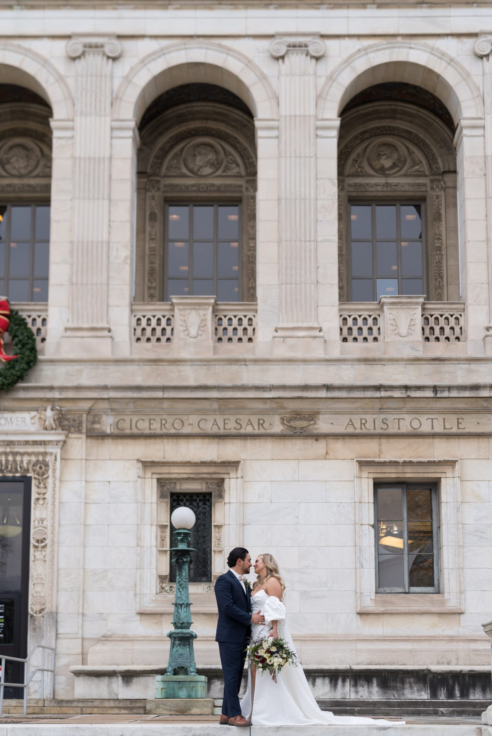 A couple almost kiss on their wedding day on the steps of the Detroit Public Library.