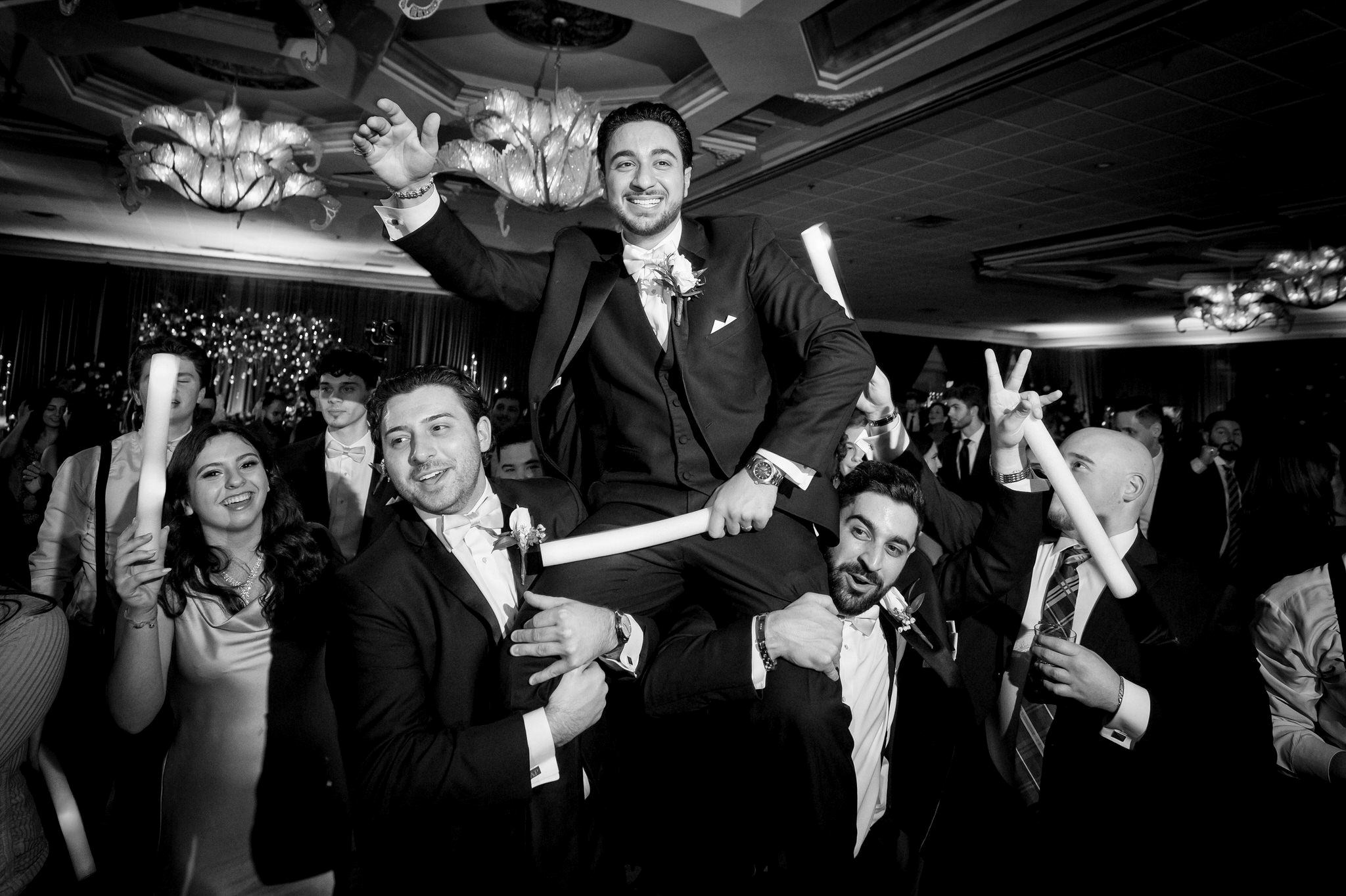 The groom is hosted on the shoulders of groomsmen on the dance floor at a Penna's of Sterling wedding.