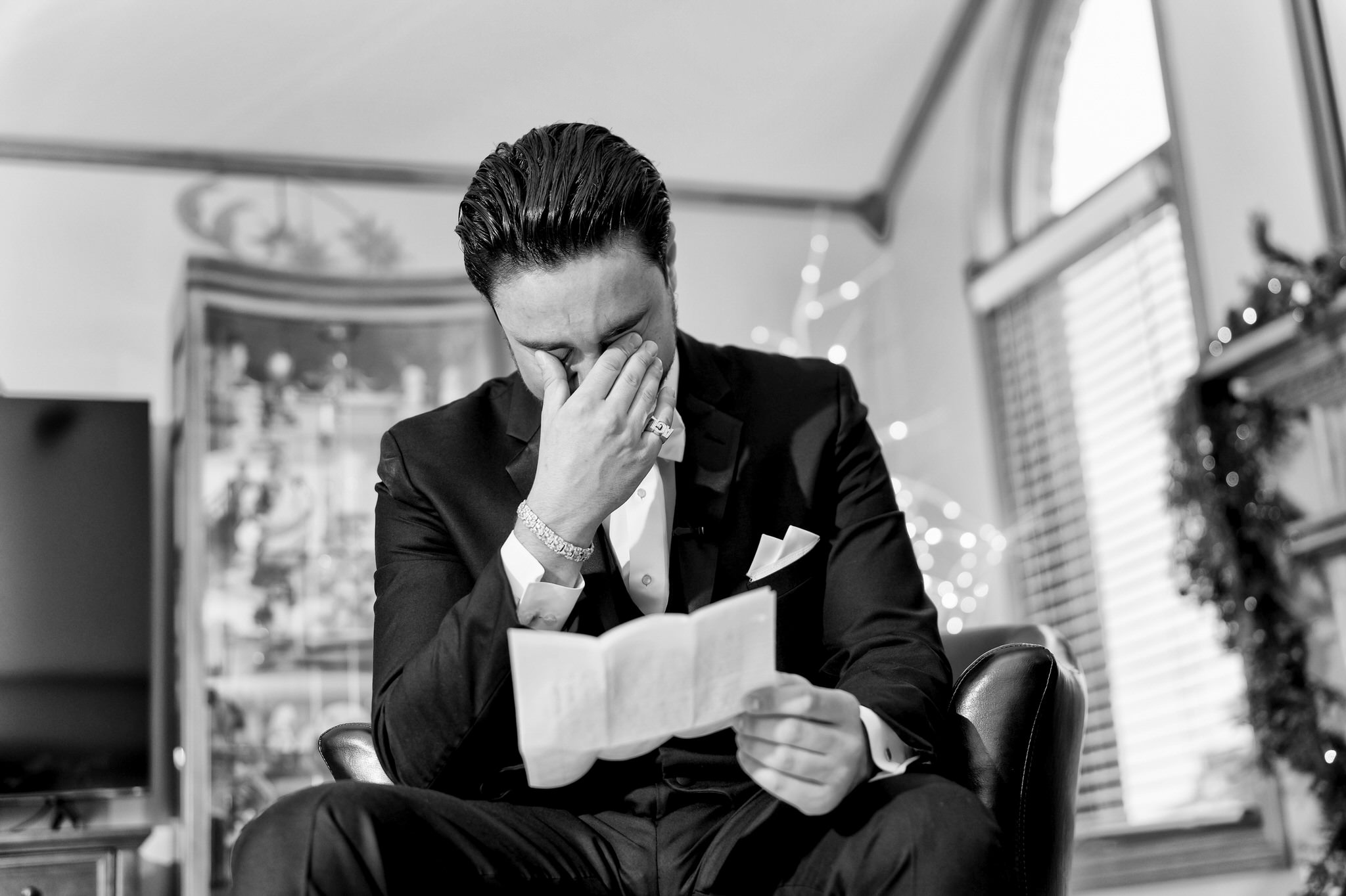 A groom reacts to reading a letter from his wife on his wedding day.  