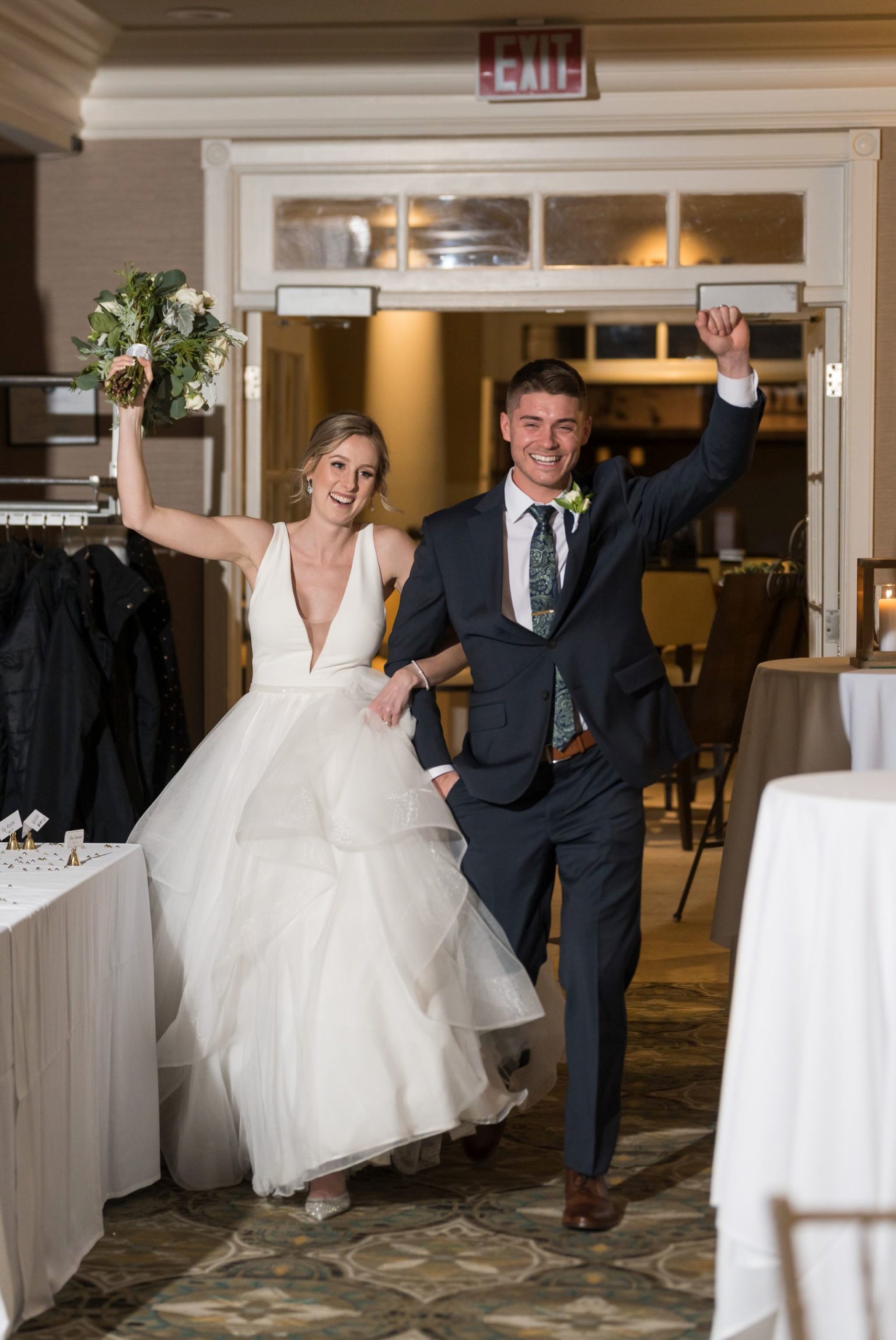 A smiling couple enters their Bay Harbor wedding reception. 