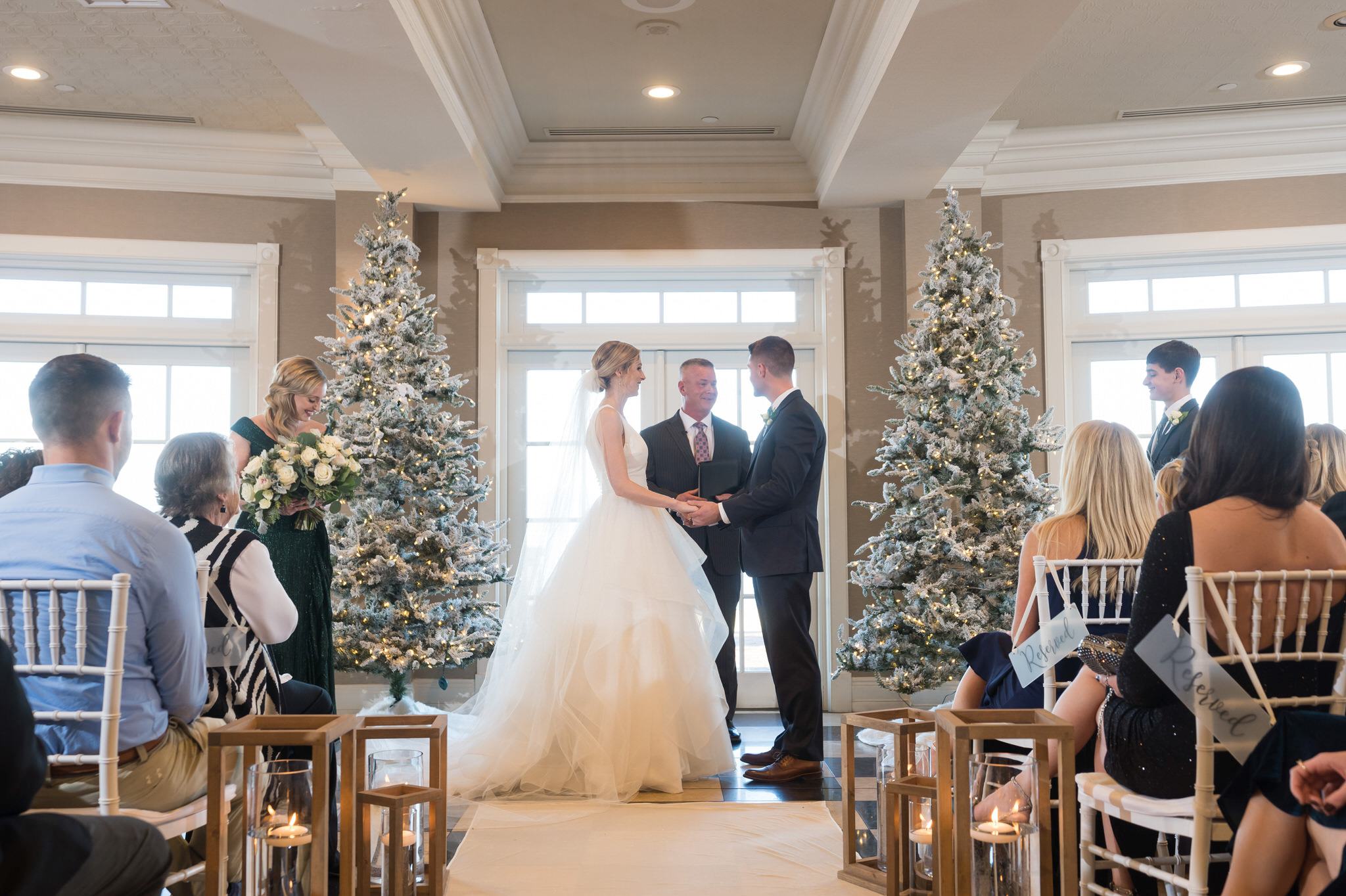 A bride and groom hold hands at their Bay Harbor wedding ceremony in the Sagamore Room. 