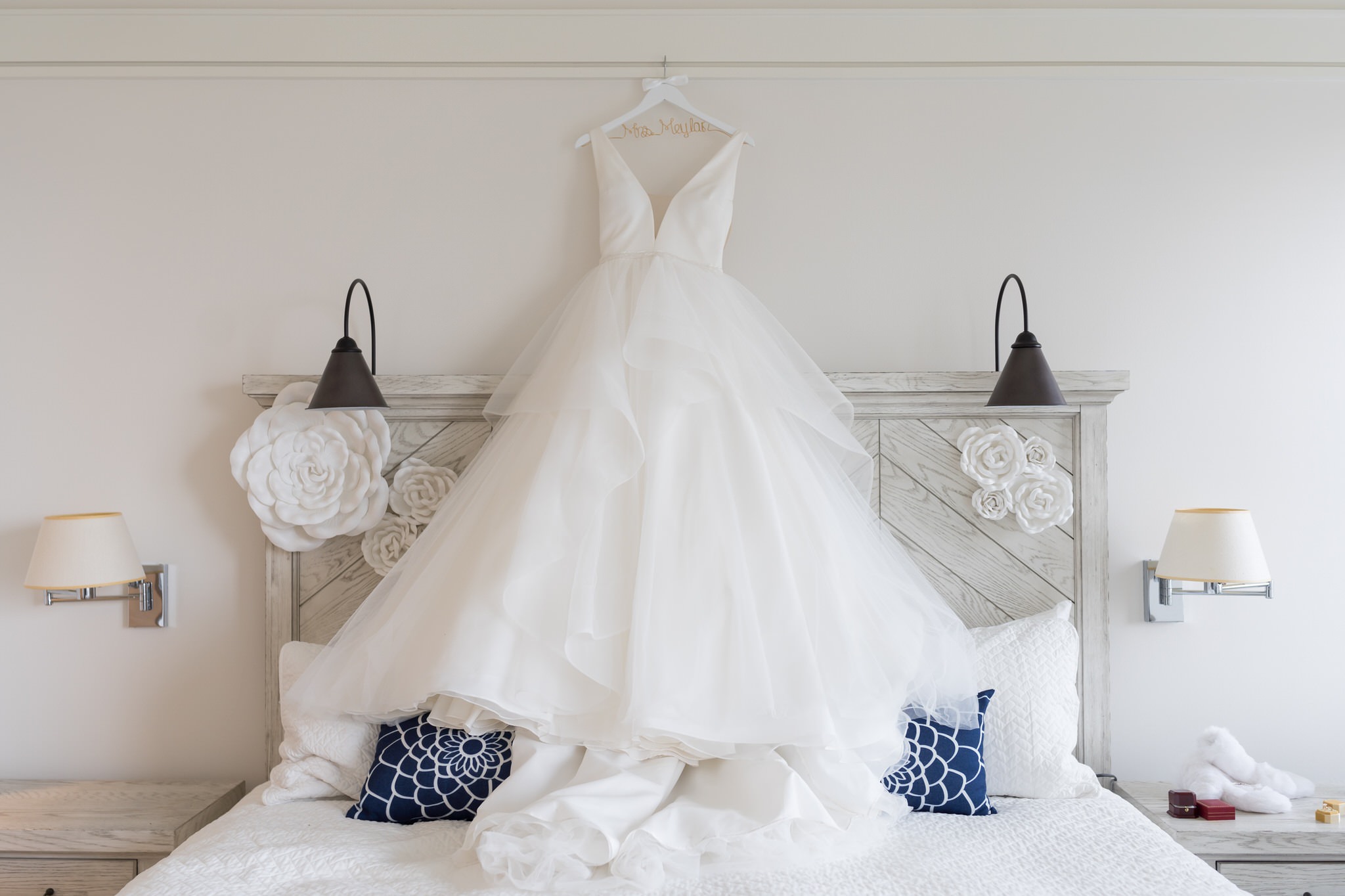 A wedding dress hangs over a bed in a room at the Inn at Bay Harbor.  