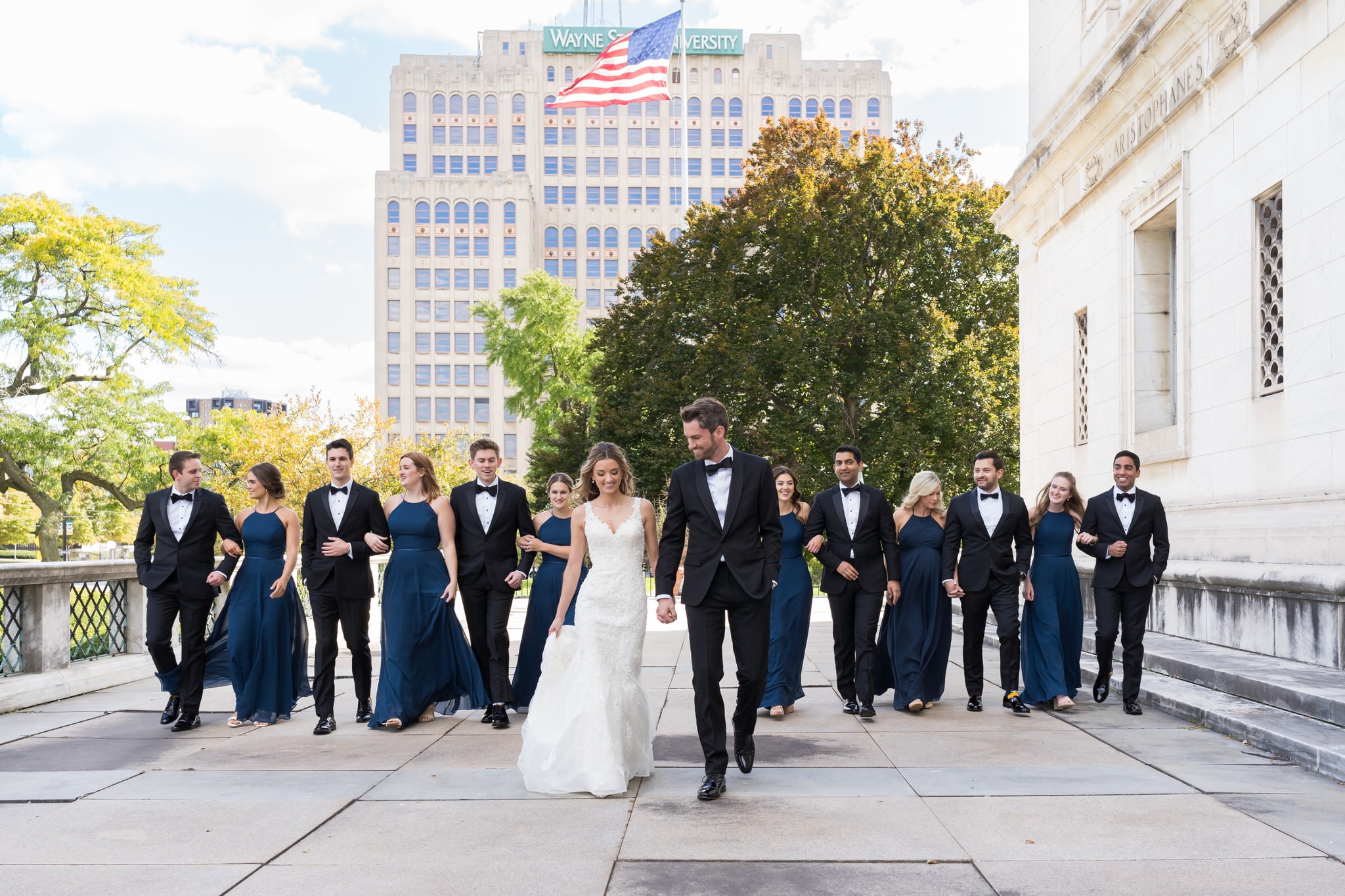 A bridal party walk together outside of the  Detroit Public Library.