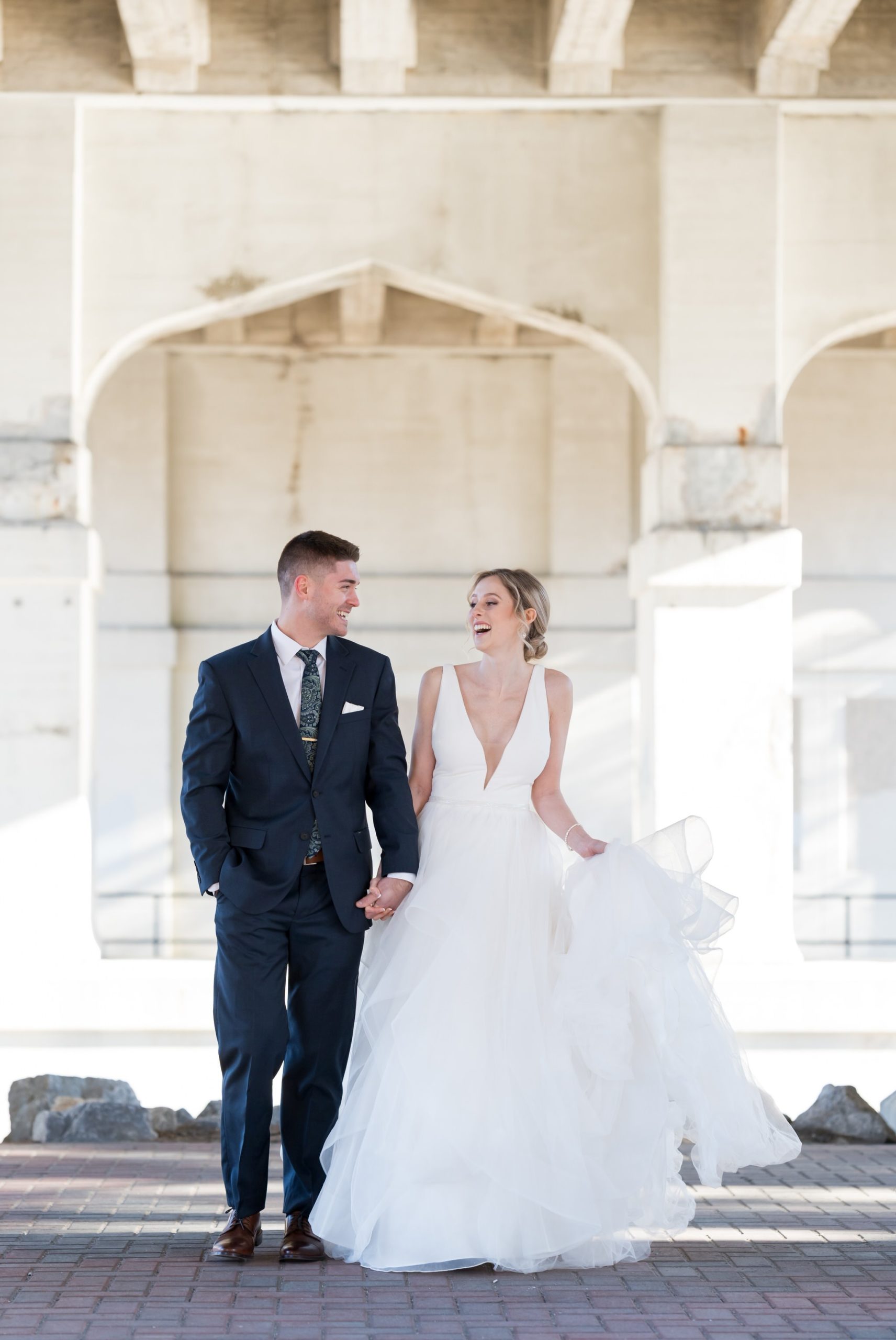 A bride and groom walk under Mitchell Street bridge in downtown Petoskey before their Bay Harbor wedding.