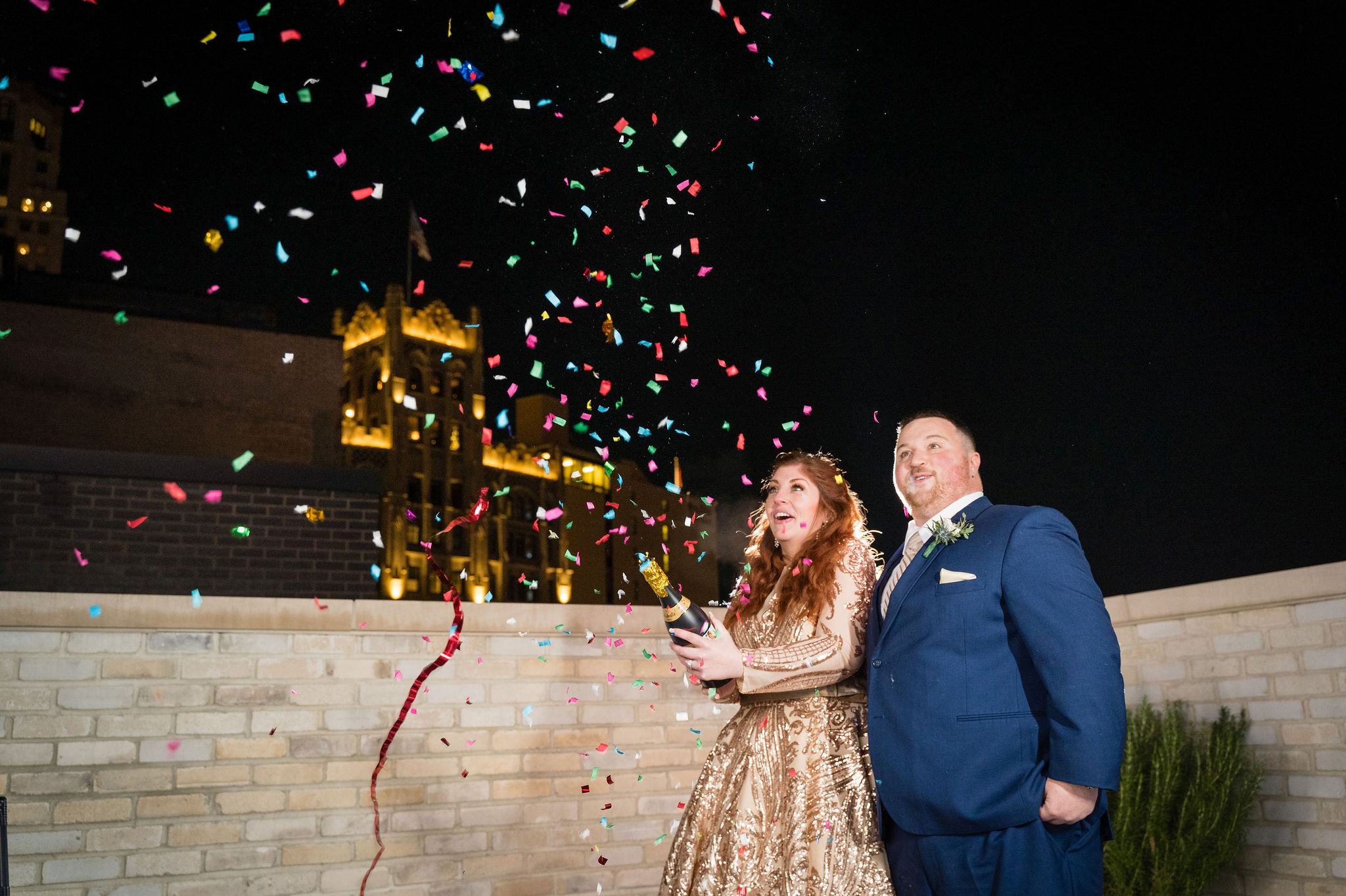A couple pops confetti at the Shinola hotel during their Detroit elopement.  