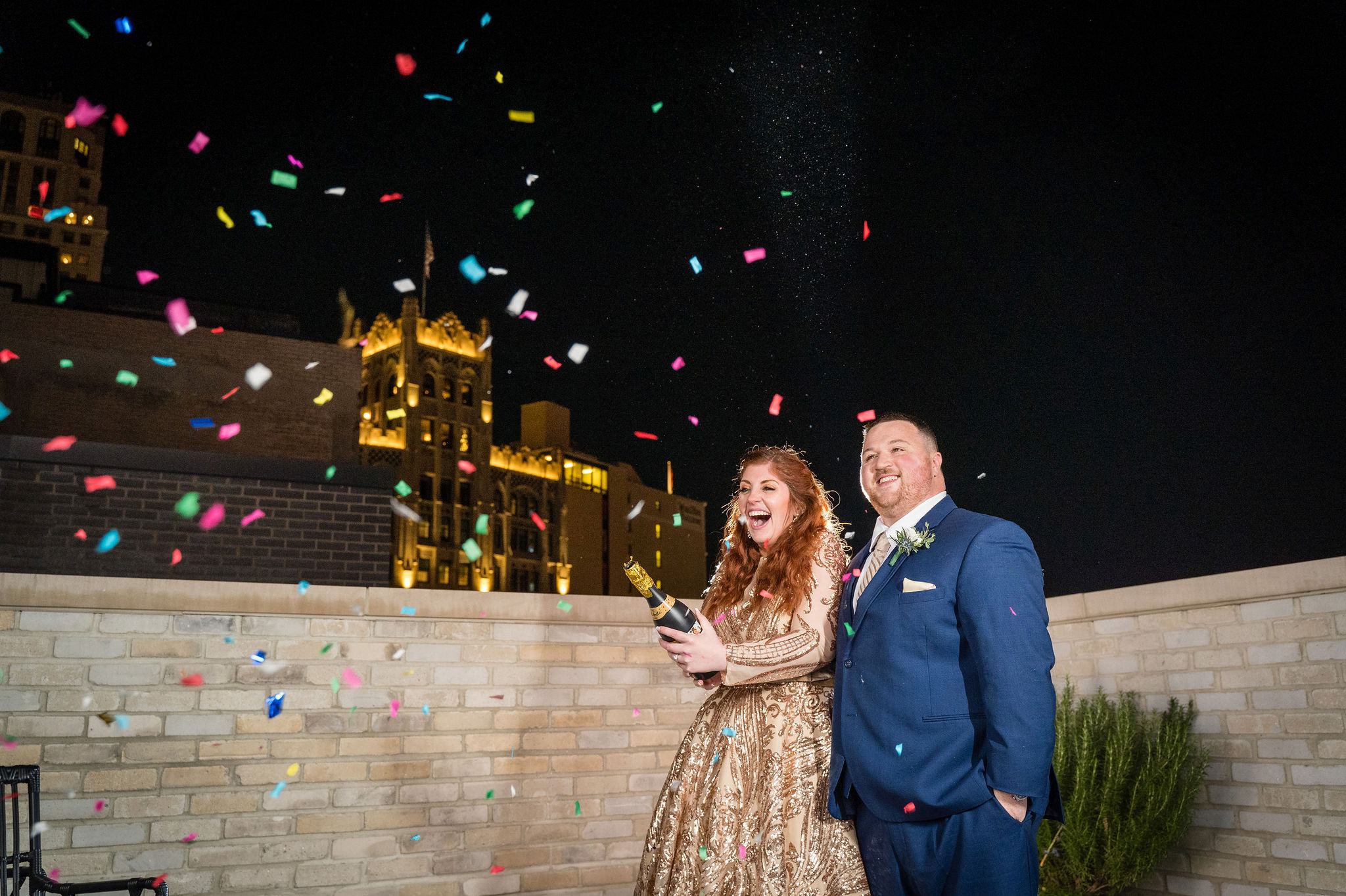 A couple pops confetti at the Shinola hotel during their Detroit elopement.  