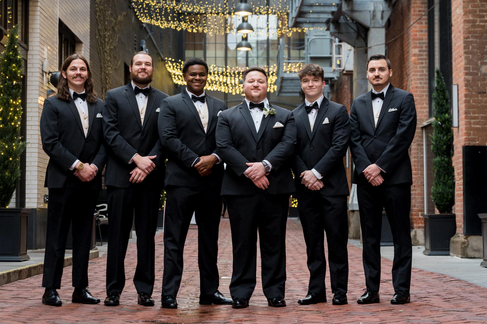 Groomsmen pose for a formal portrait in Parker's Alley in Detroit, Michigan. 