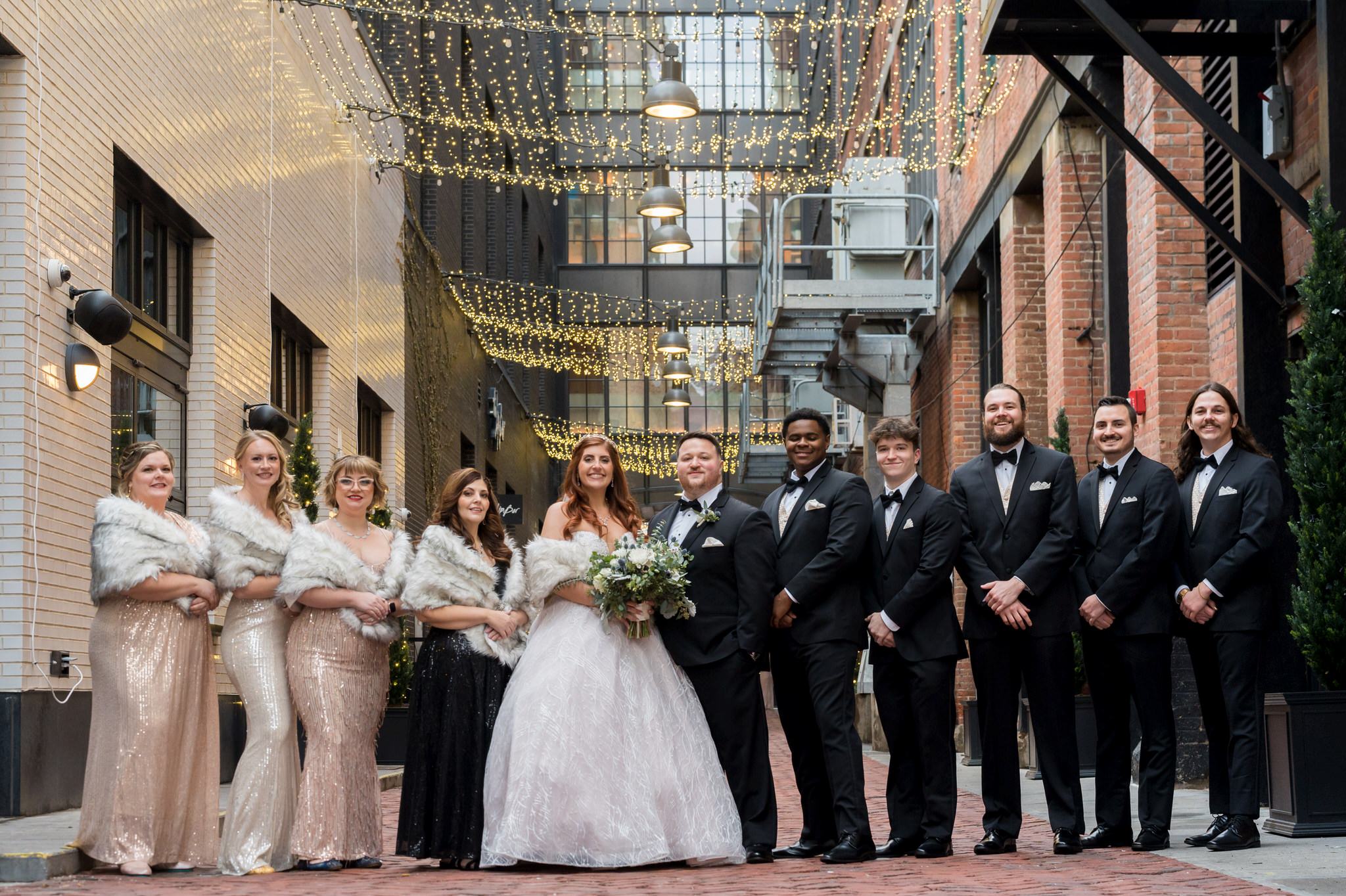The bridal party poses for a formal portrait in Parker's Alley in Detroit, Michigan by Brian Weitzel Photography on New Years Eve.