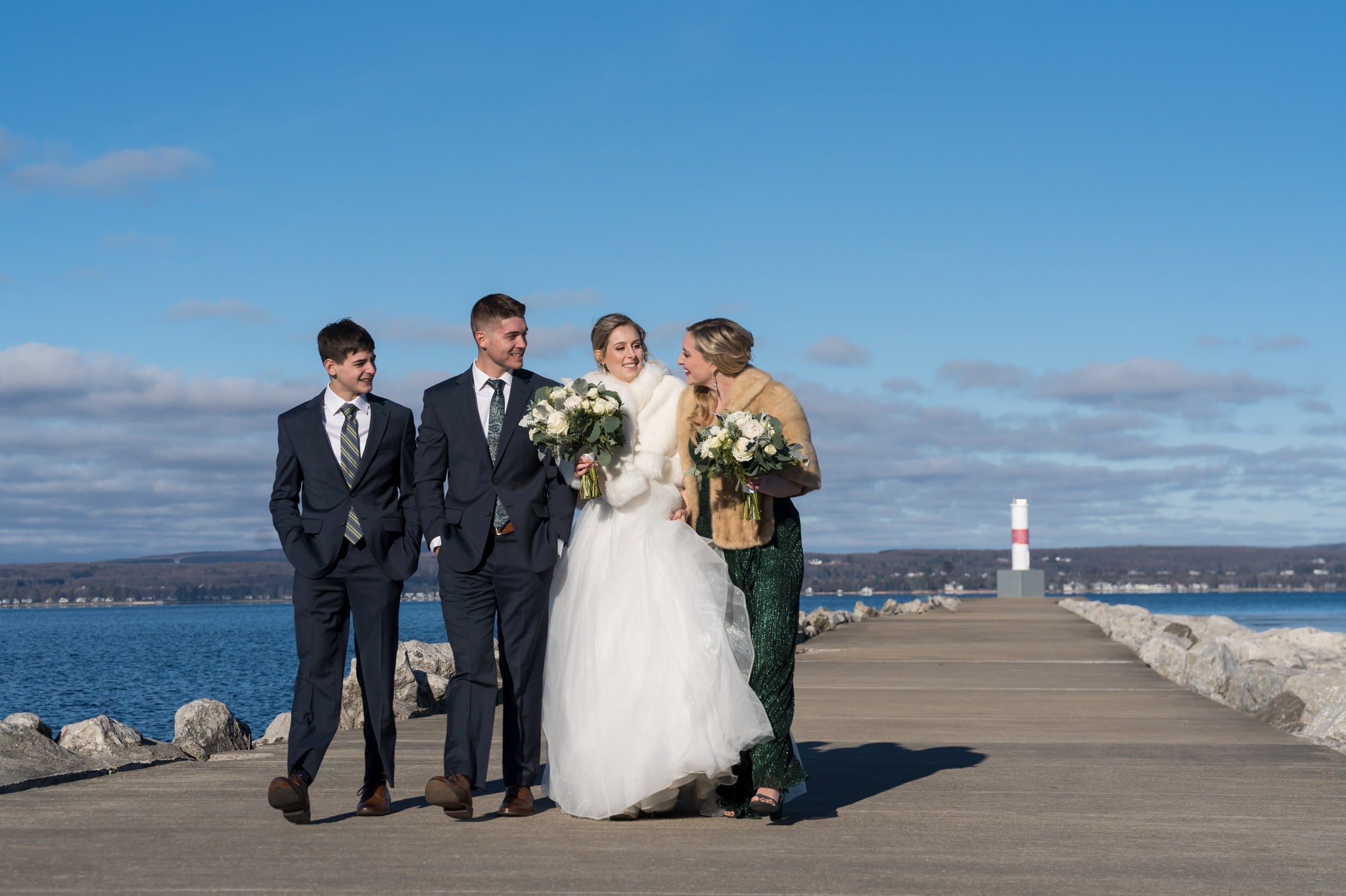 A bridal party walks down the lighthouse pier in Petoskey.