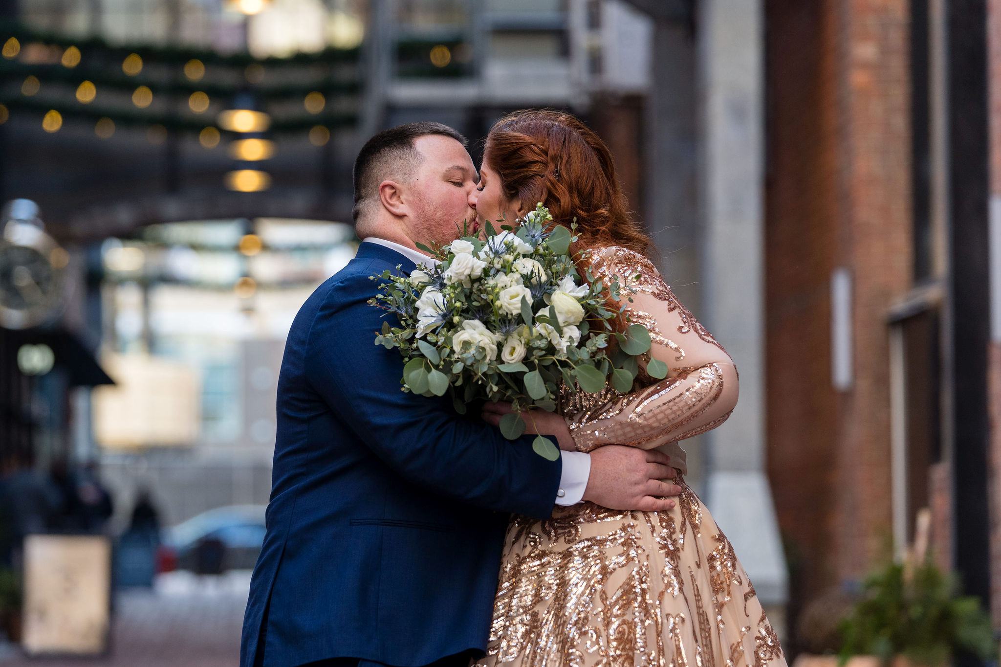 A bride and groom kiss in Parker's Alley outside of Shinola Hotel.