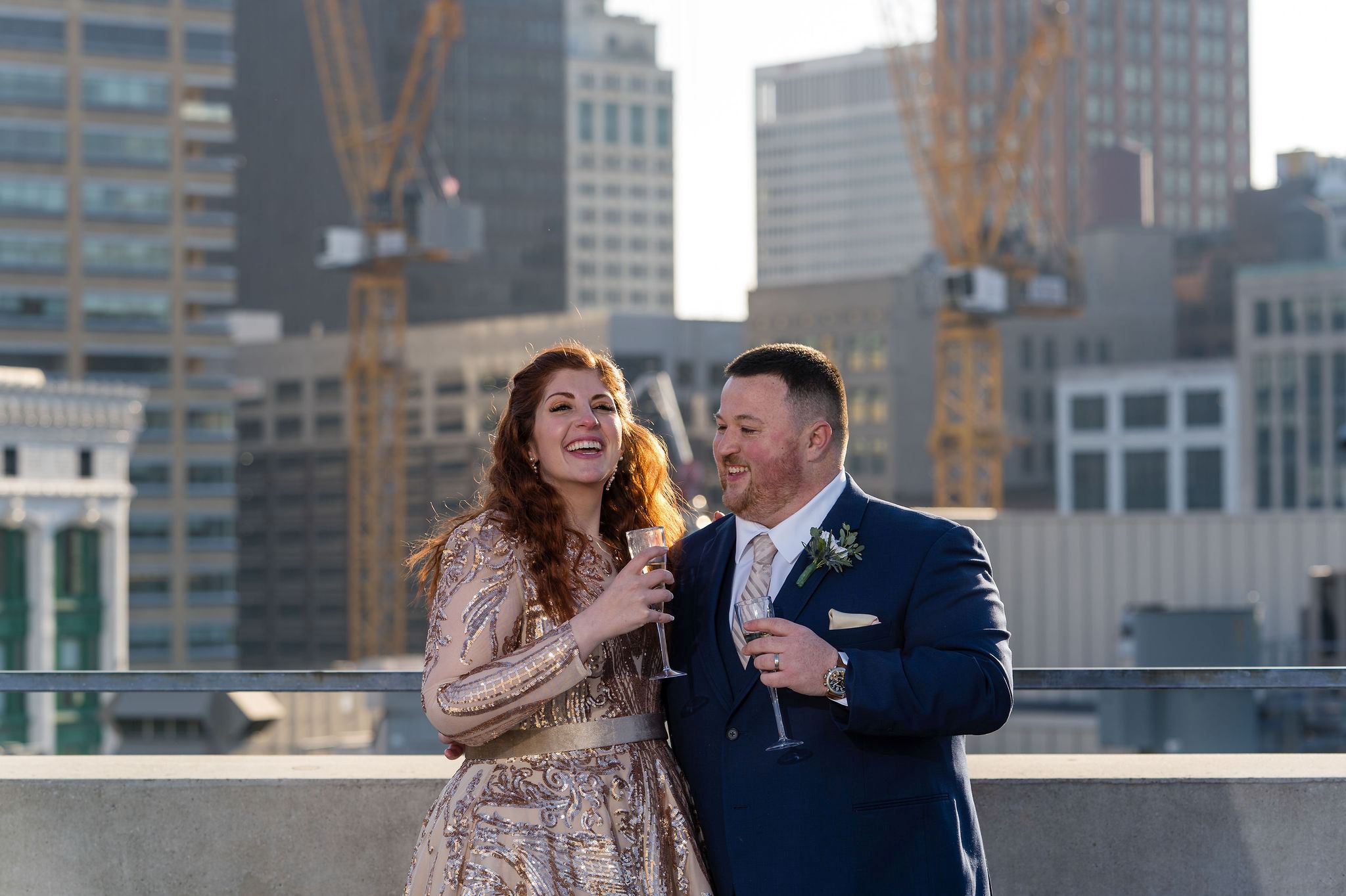 A couple shares glasses of champagne on a rooftop during their Detroit elopement.  