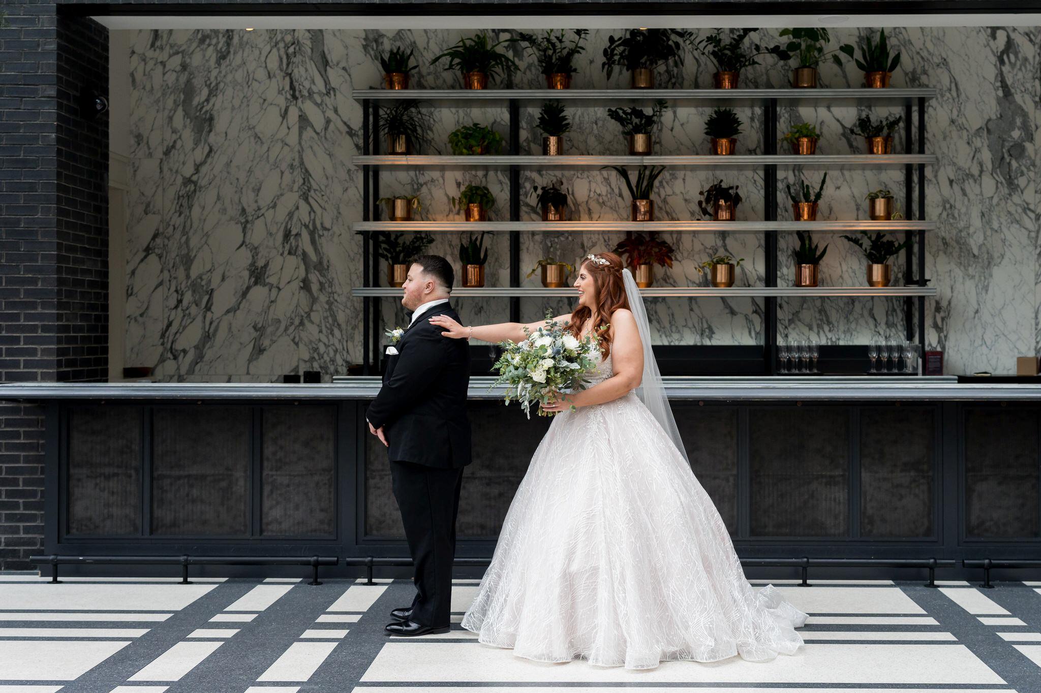 A bride and groom share a first look inside the Shinola Hotel wedding.