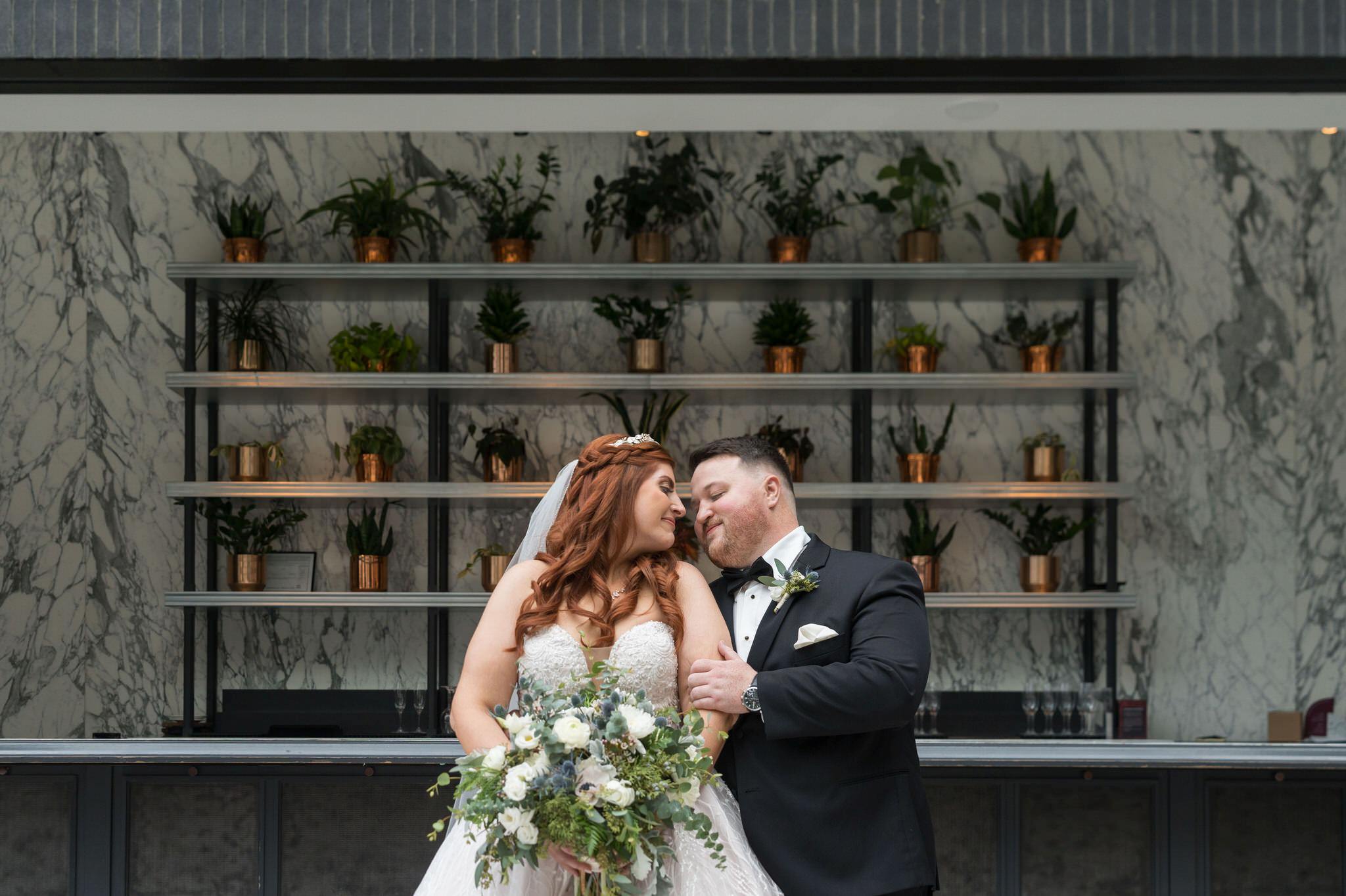 A bride and groom pose in the Shinola Hotel wedding ceremony area. 