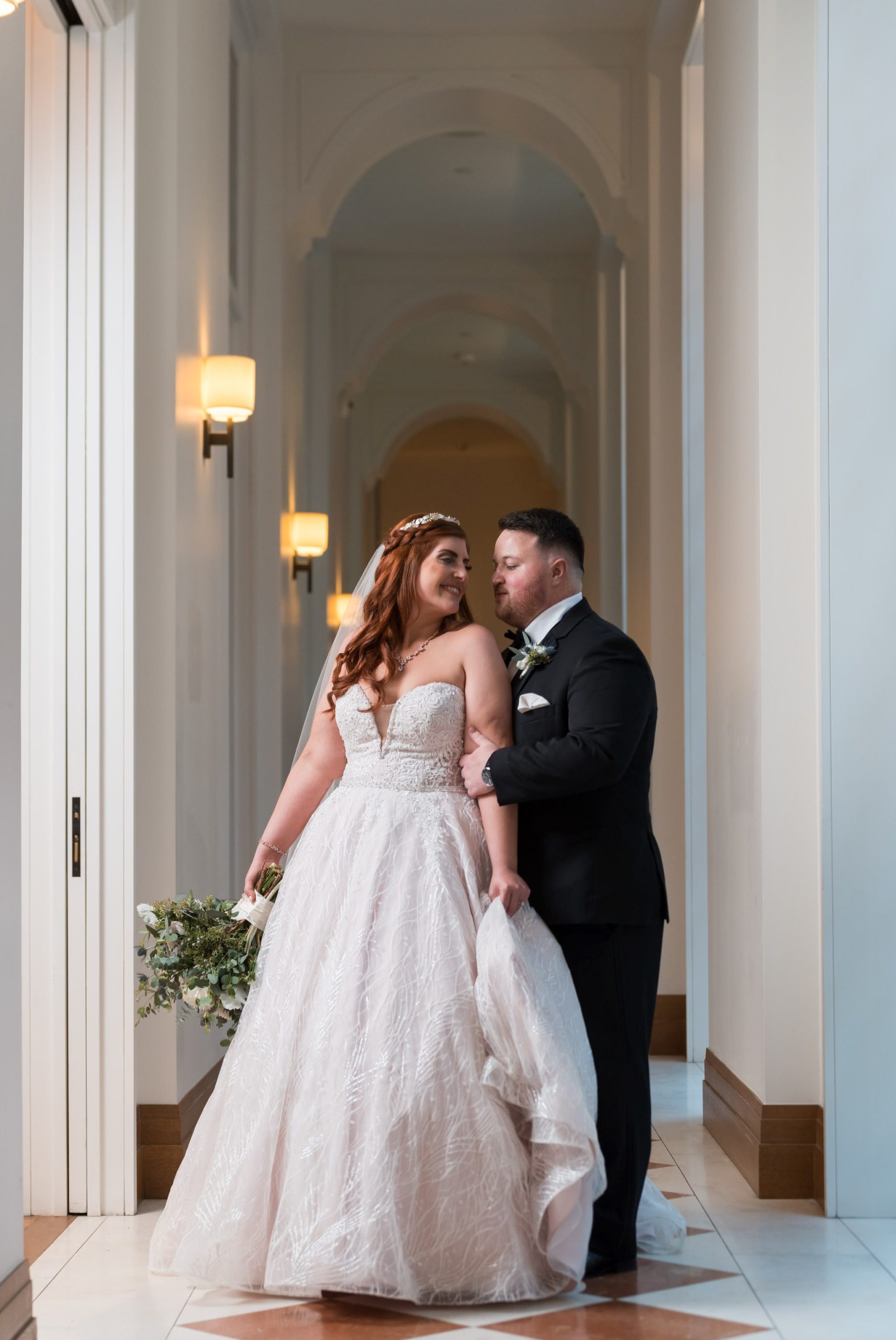 A bride and groom hugs inside a hallway at their Shinola Hotel wedding. 