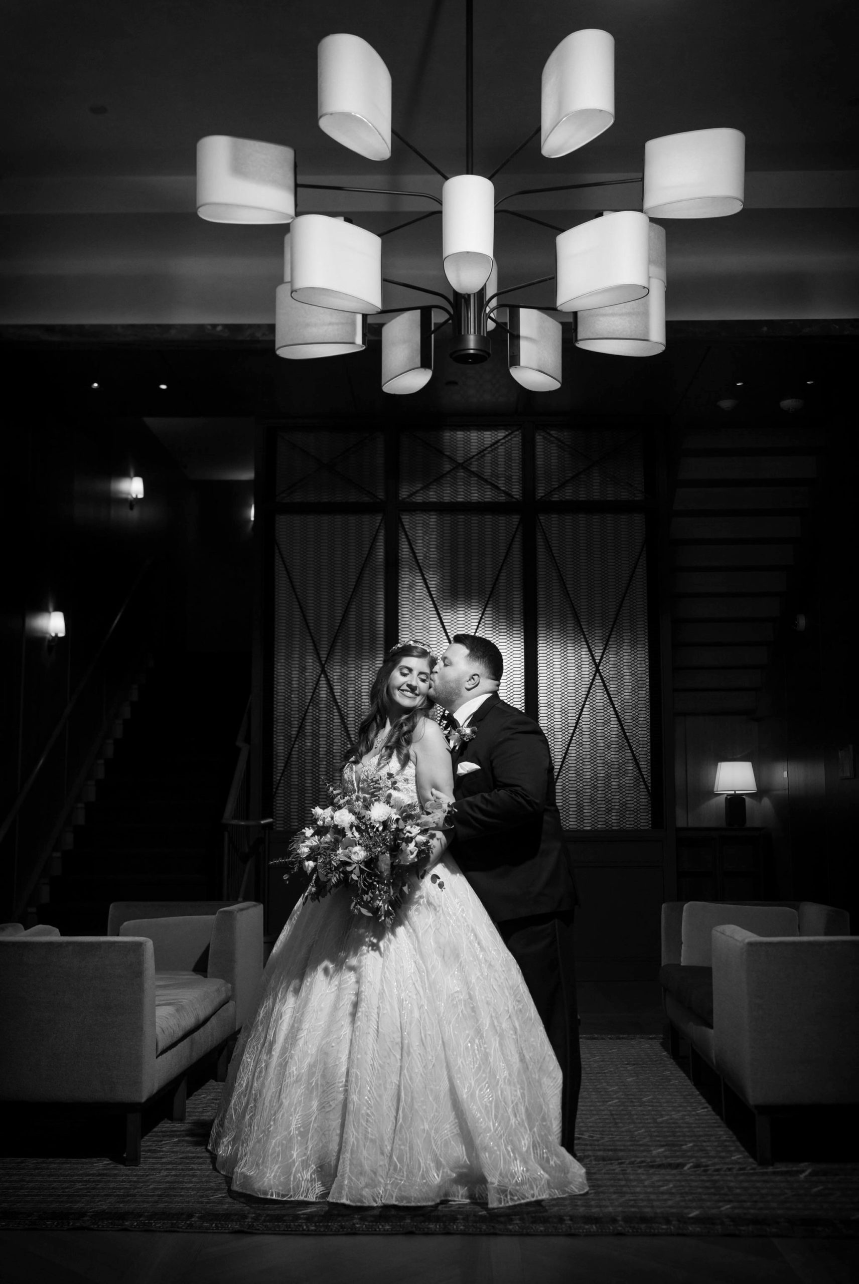 A couple kisses in a romantic lobby at a Shinola Hotel wedding.