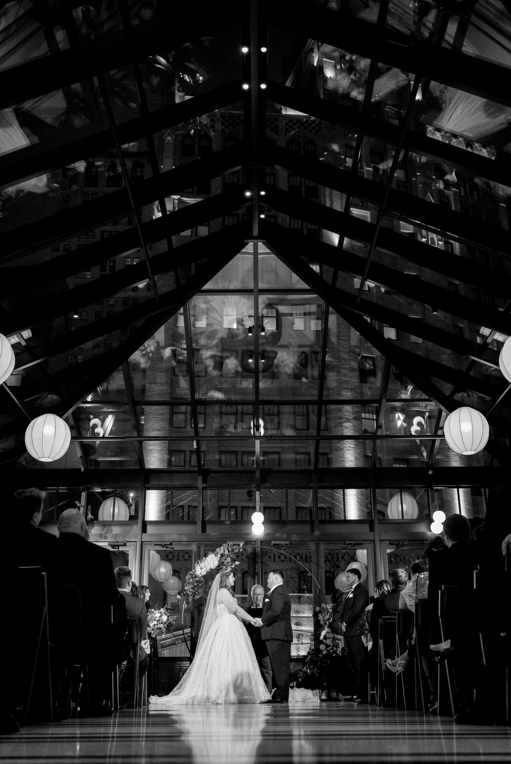 A bride and groom hold hands during their ceremony at a Shinola Hotel wedding.