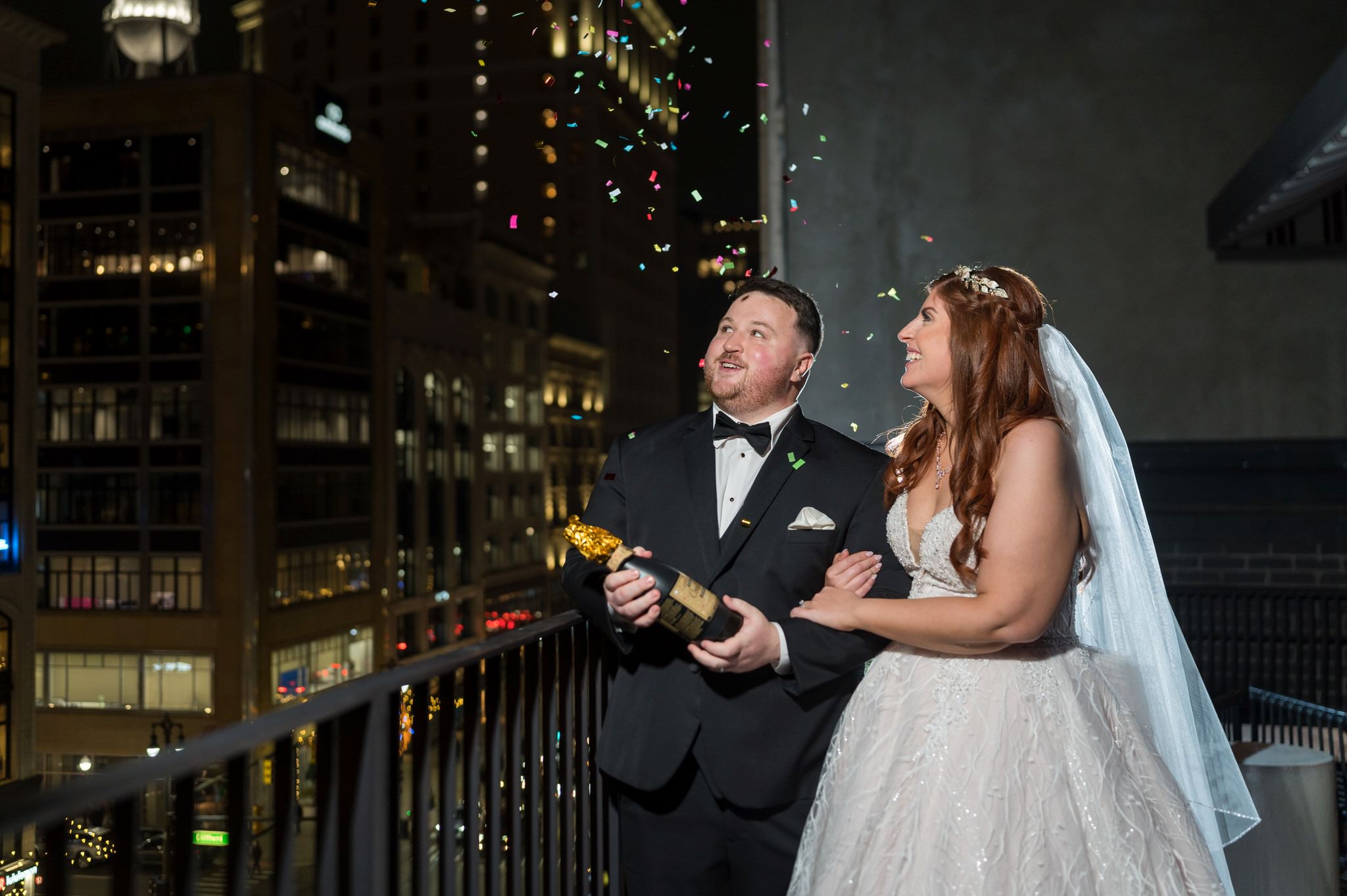 A bride and groom pop confetti on the streets of Detroit. 
